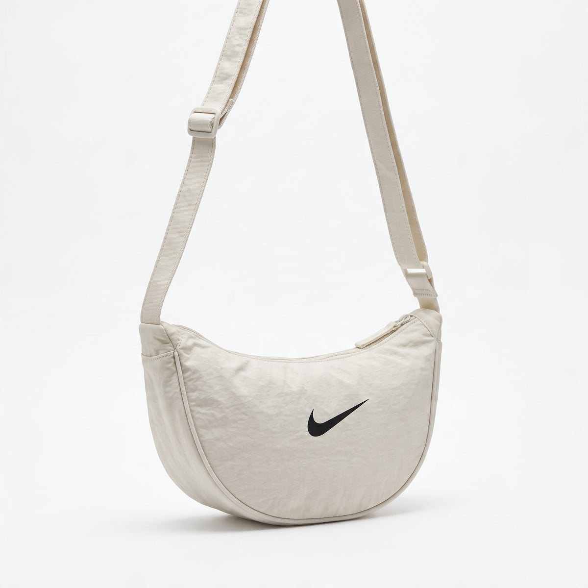 cream Nike crescent shoulder bag with adjustable strap and black Swoosh