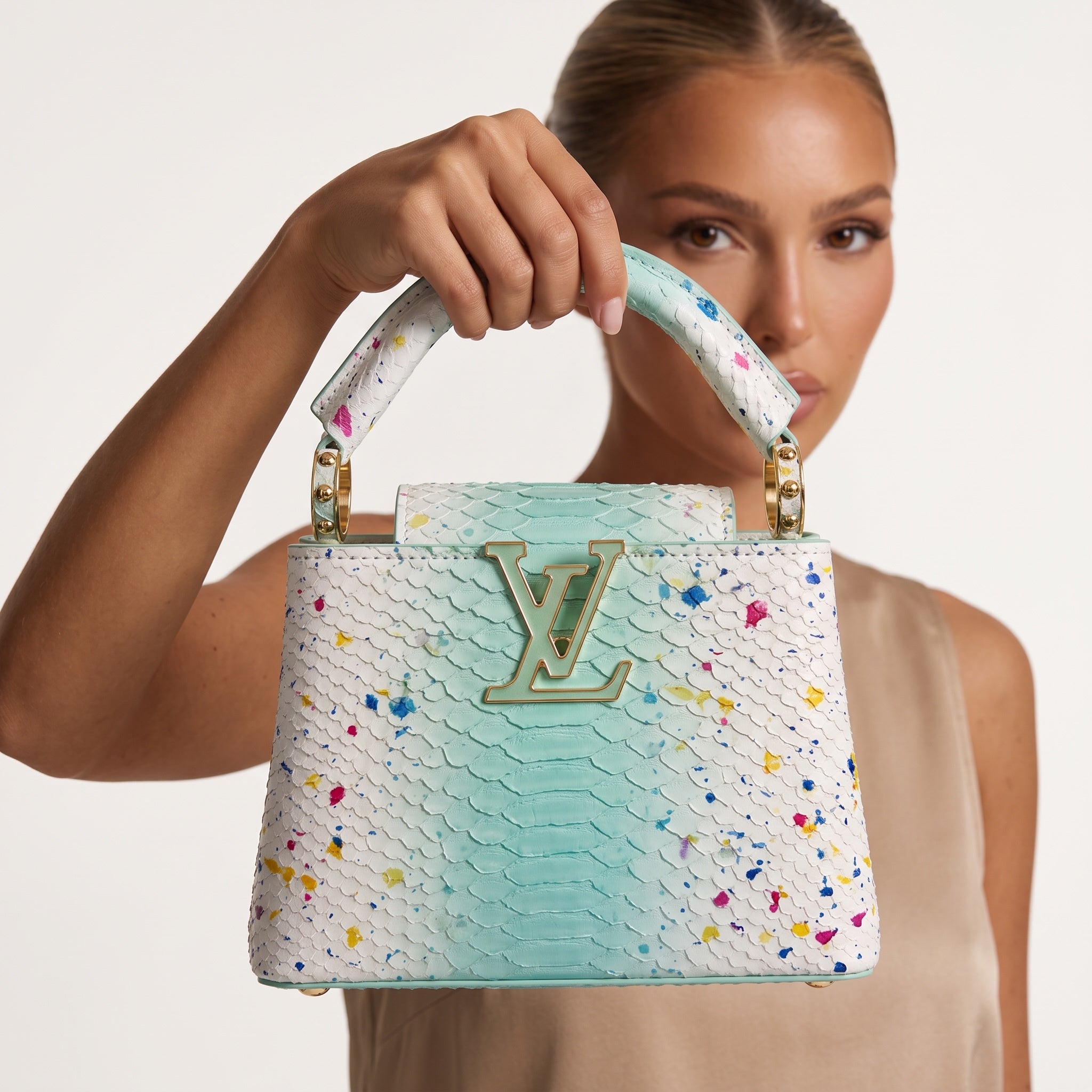 Louis Vuitton Capucines top-handle bag mint white with multicolor paint splatter and gold LV hardware held by model