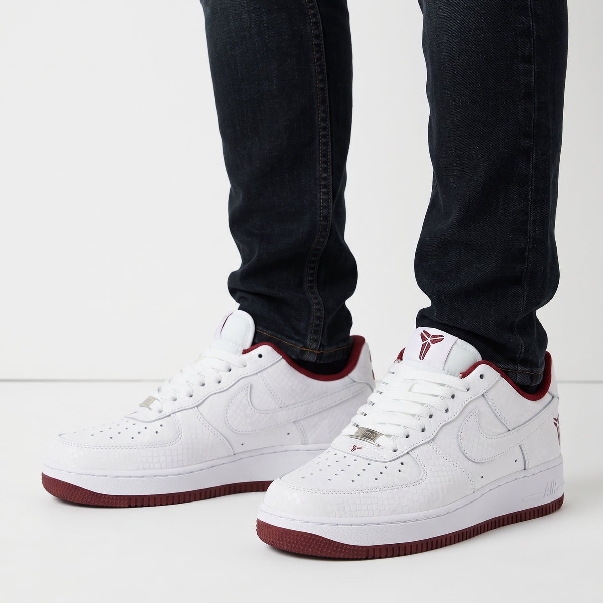 White low-top Nike Air Force 1 with burgundy accents, textured upper, Kobe logo and number 33 on heel