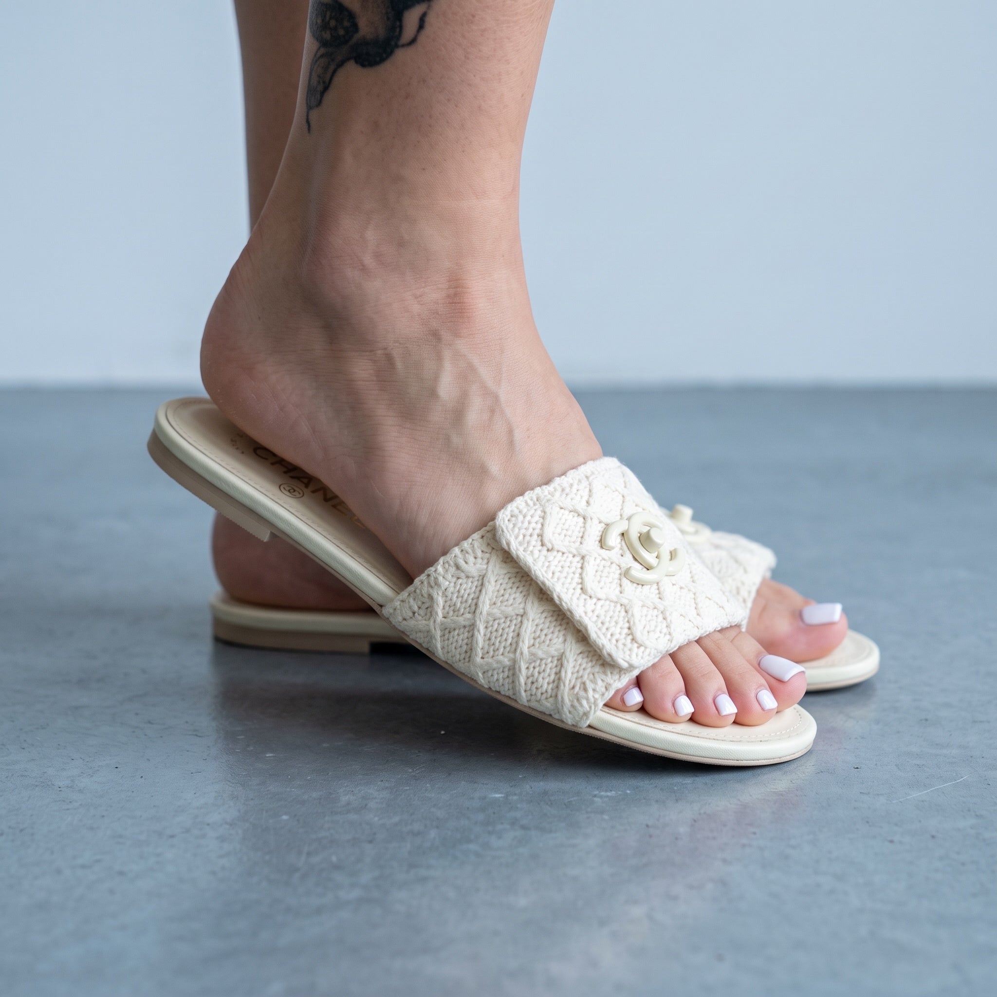 Ivory Chanel crochet slide mule with CC logo on vamp shown on model feet