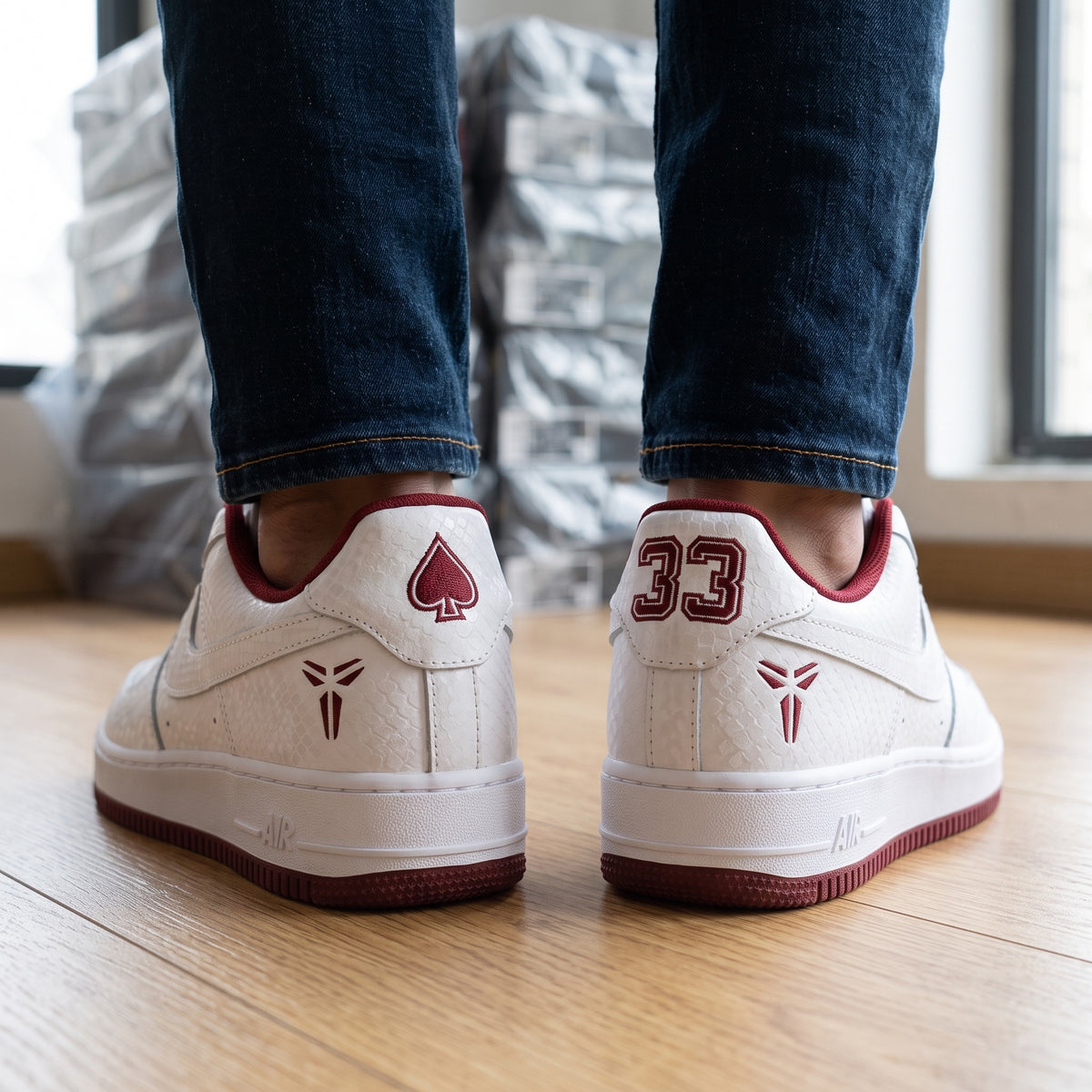 White low-top Nike Air Force 1 with burgundy accents, textured upper, Kobe logo and number 33 on heel