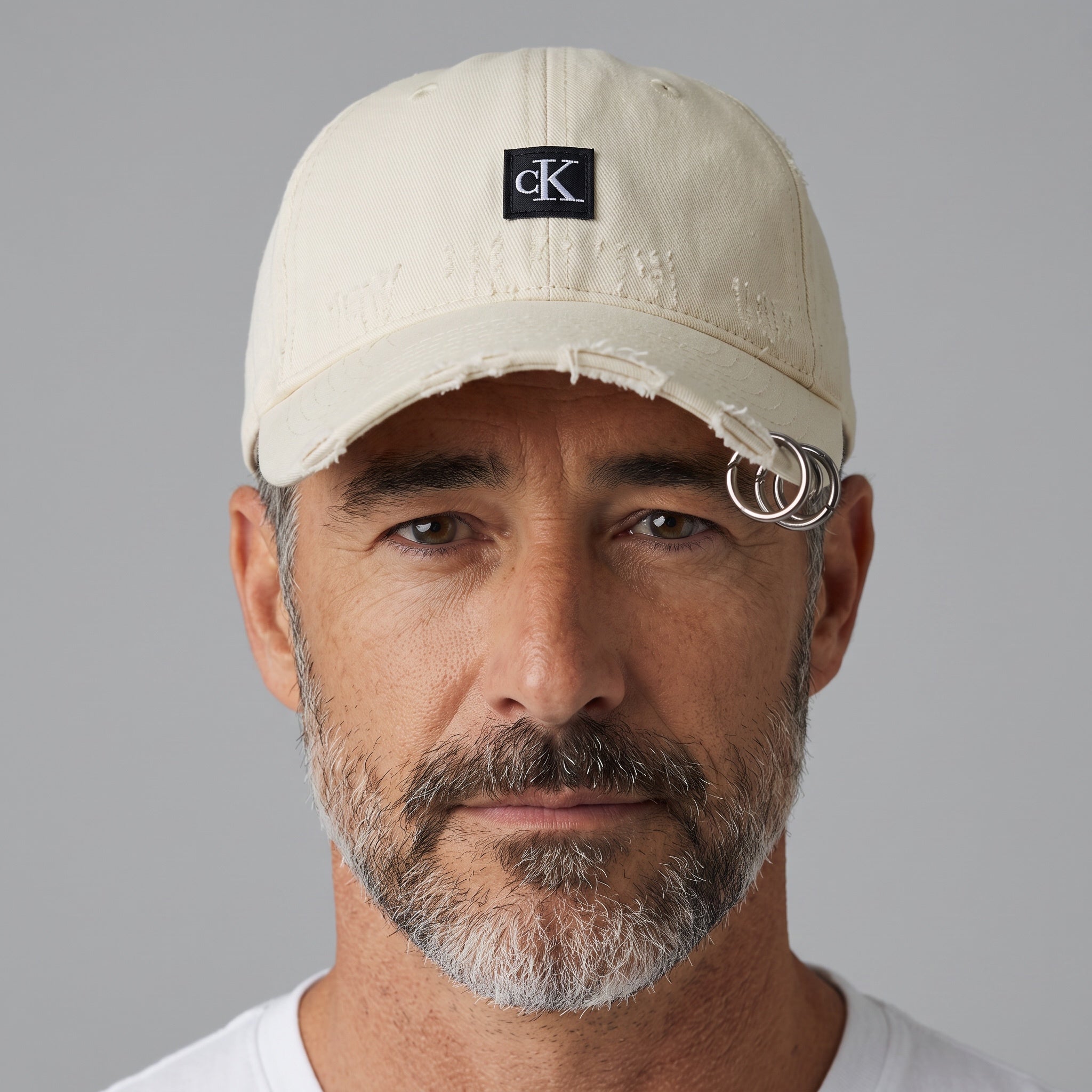 Man wearing a cream beige distressed Calvin Klein CK baseball cap