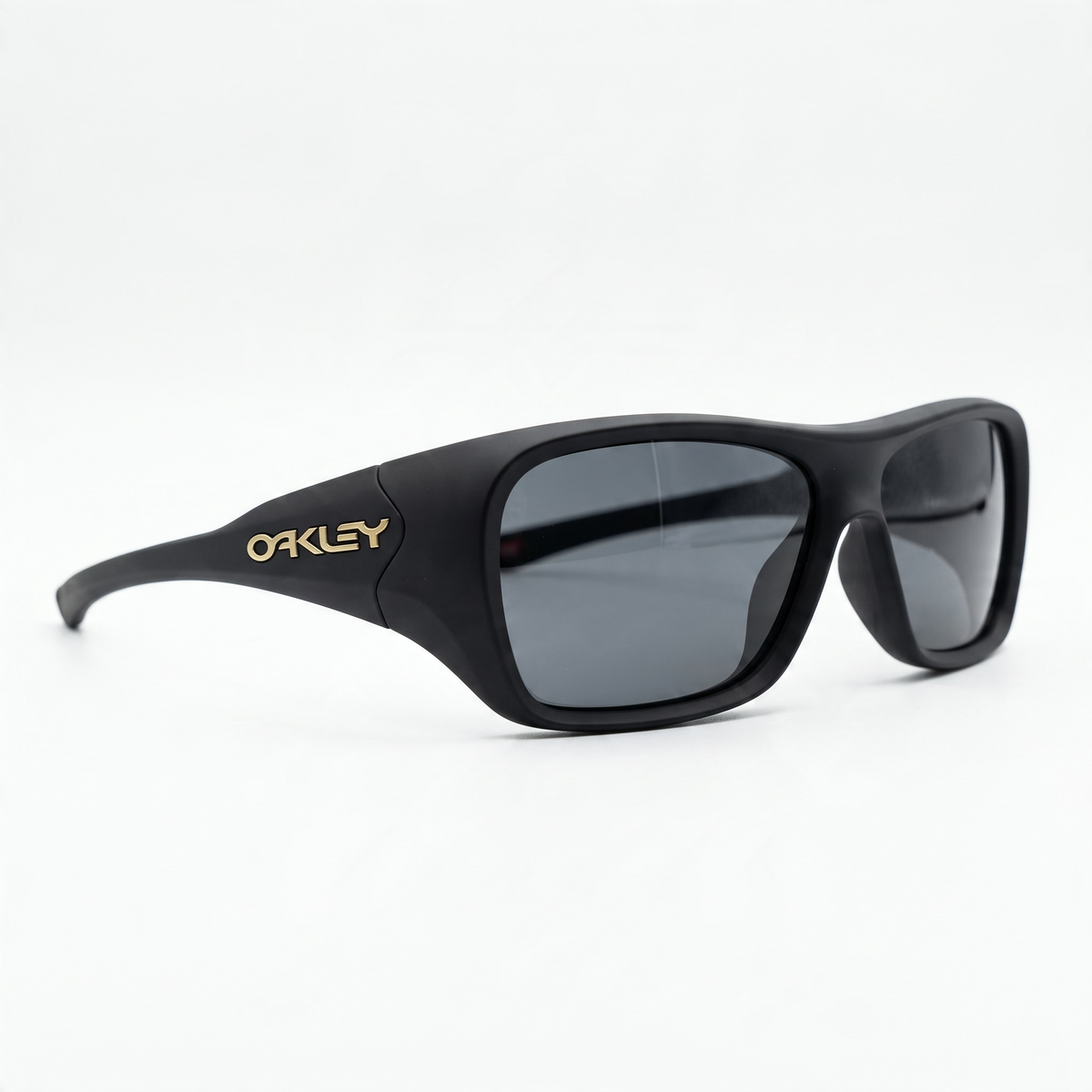 Oakley matte black sunglasses with dark lenses and gold logo on temple