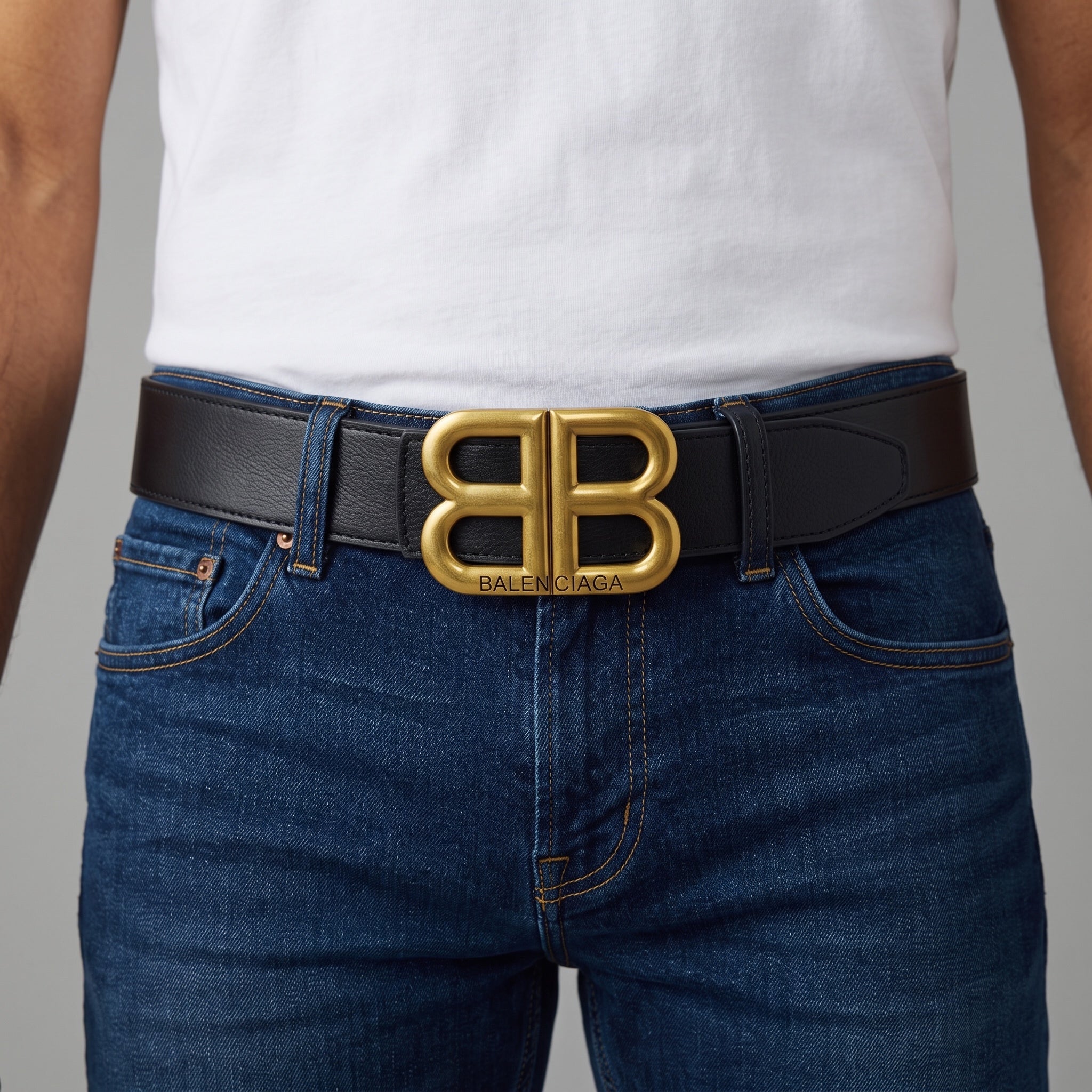 Black Balenciaga belt with large gold double B buckle on jeans