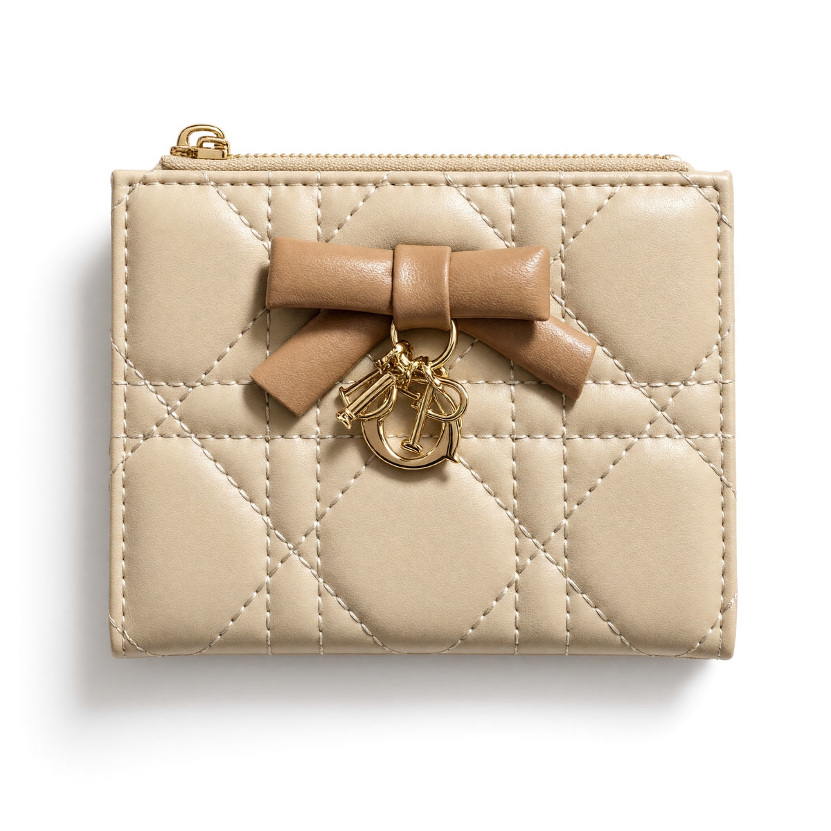 Beige Dior quilted compact wallet with bow and gold charm, open showing card slots and zip