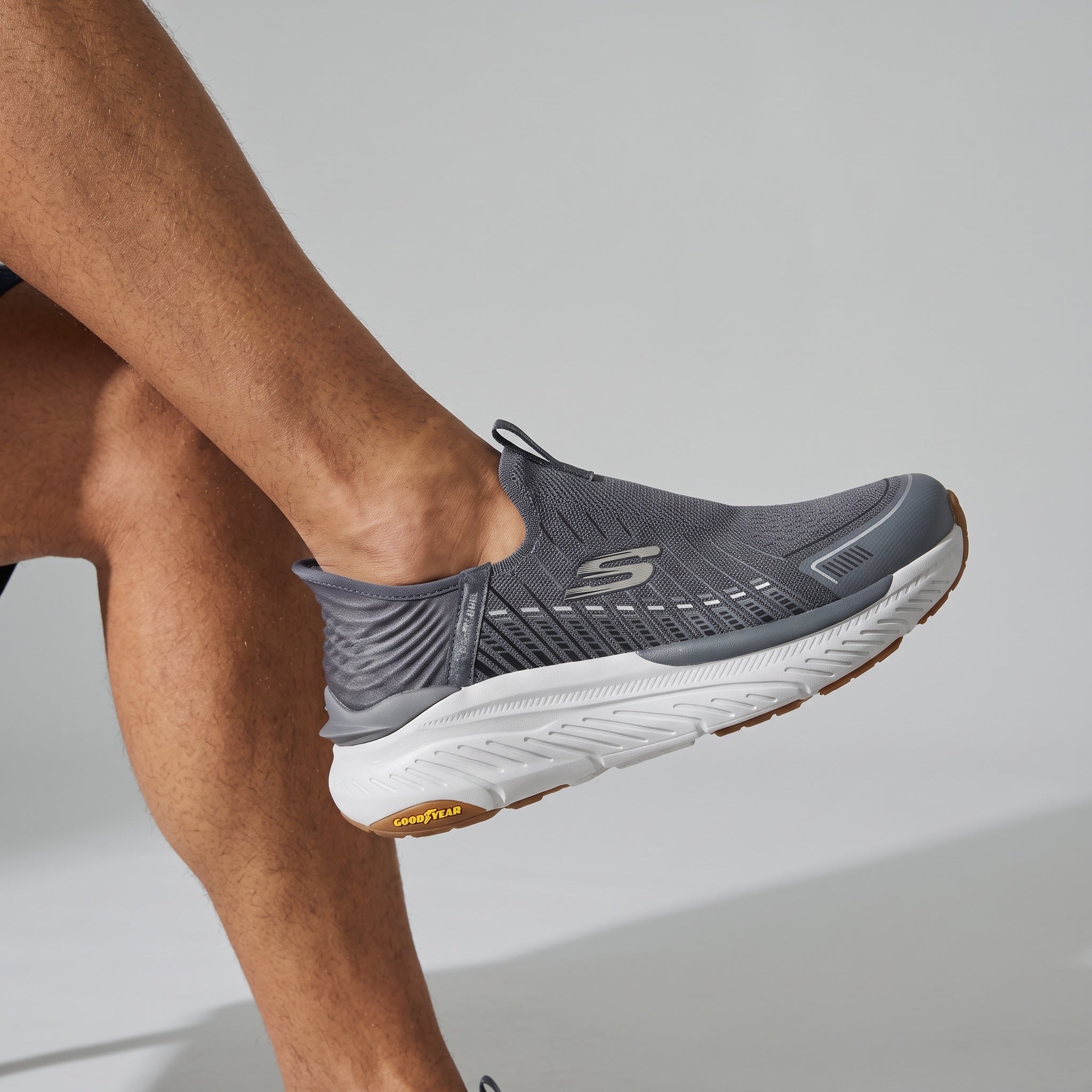 Grey Skechers slip-on knit trainer with white midsole and Goodyear gum outsole