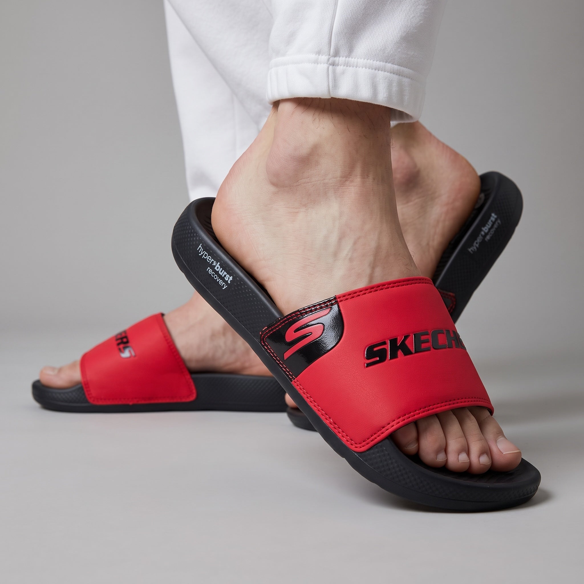 Red Skechers slide with black hyperburst recovery sole, worn on model feet