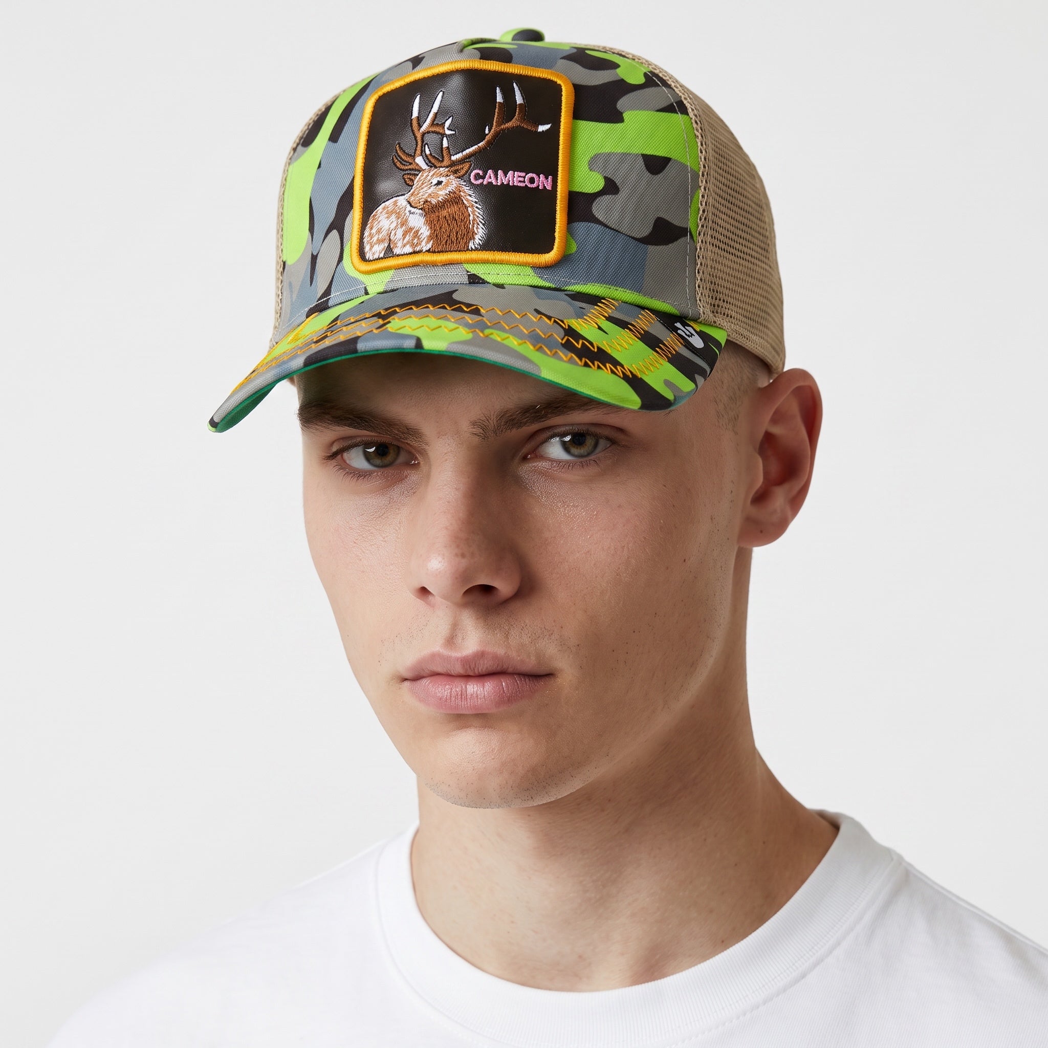 green camo trucker cap with embroidered stag patch and beige mesh back