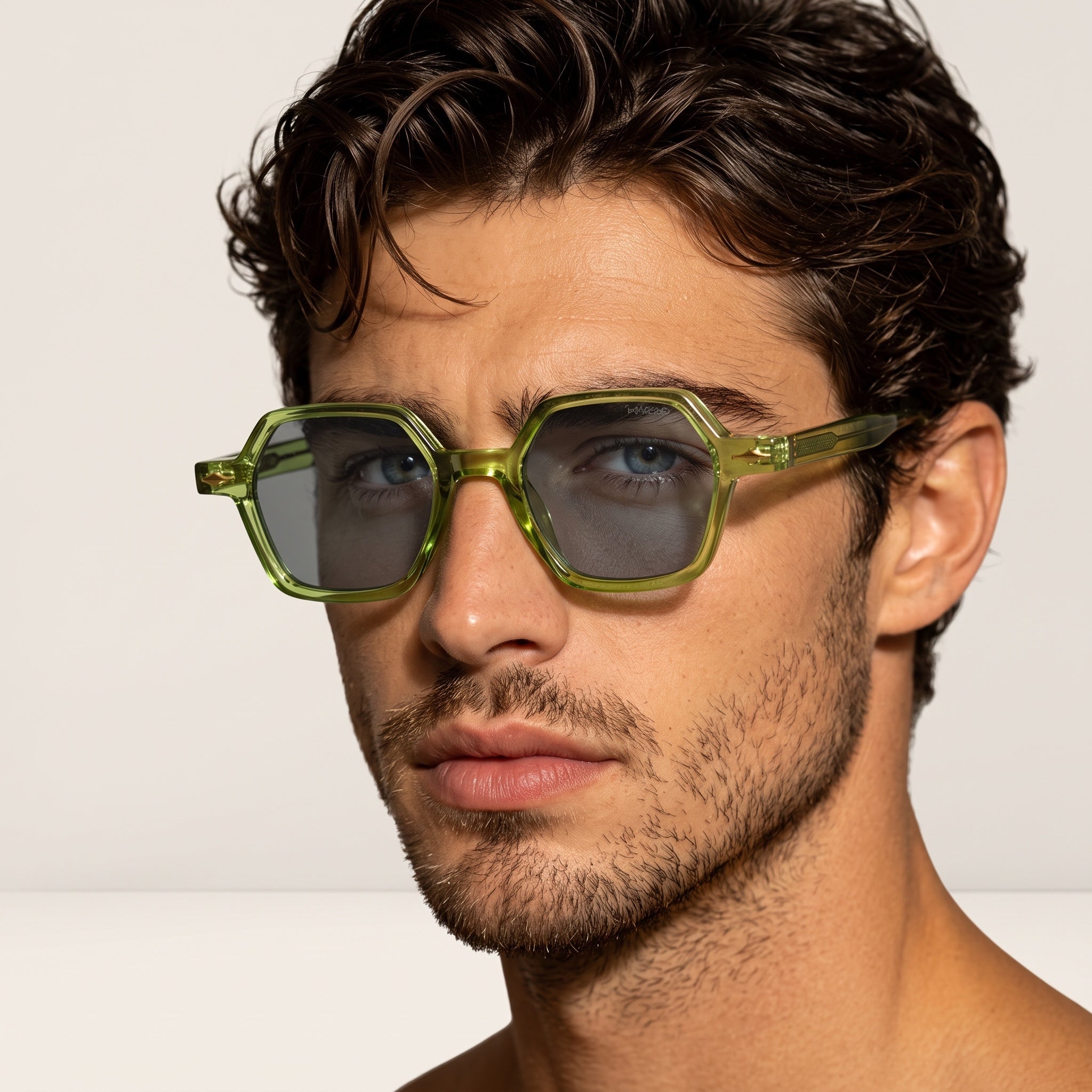 Close-up green hex-frame sunglasses on male model