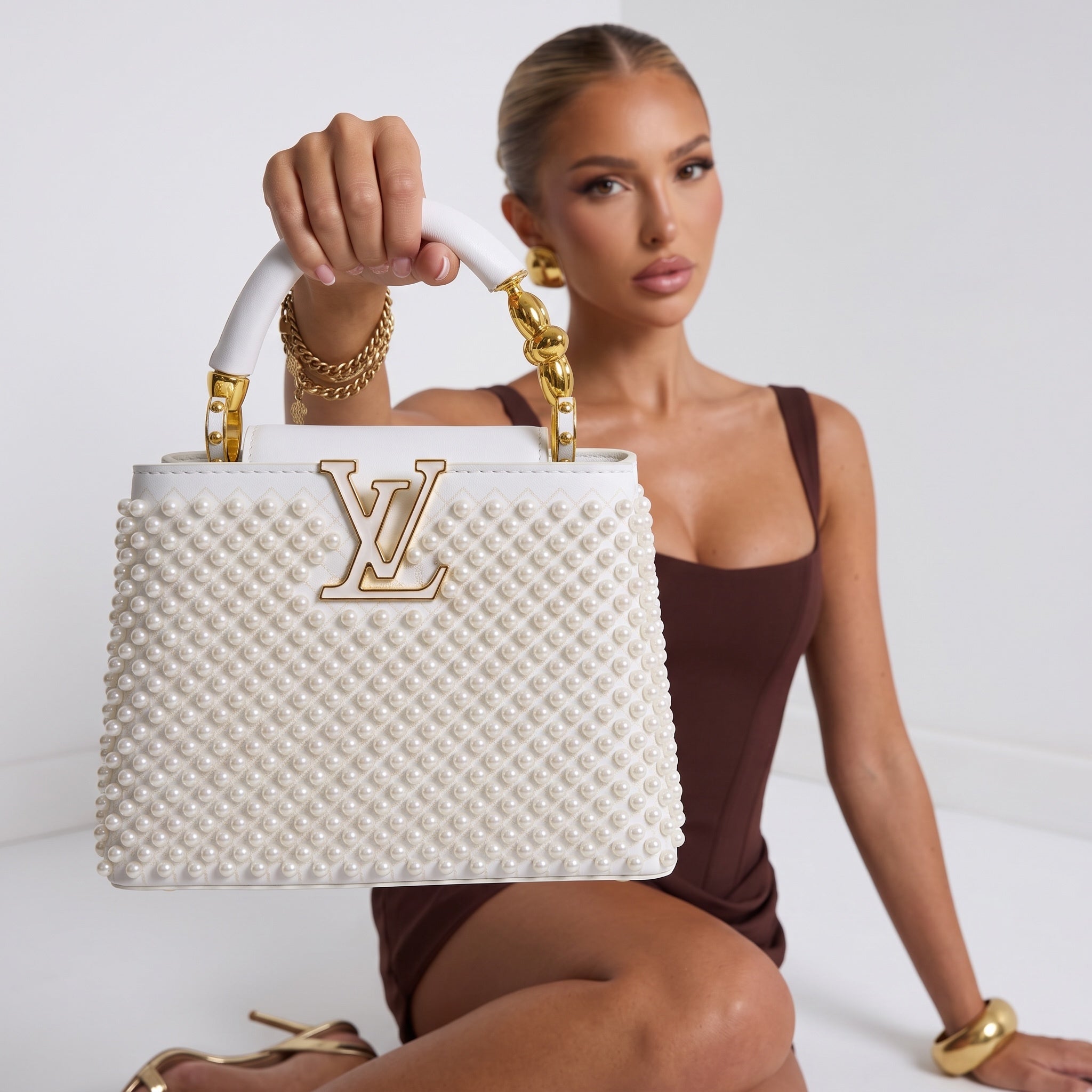 White Louis Vuitton top-handle bag with pearl studs and gold LV logo