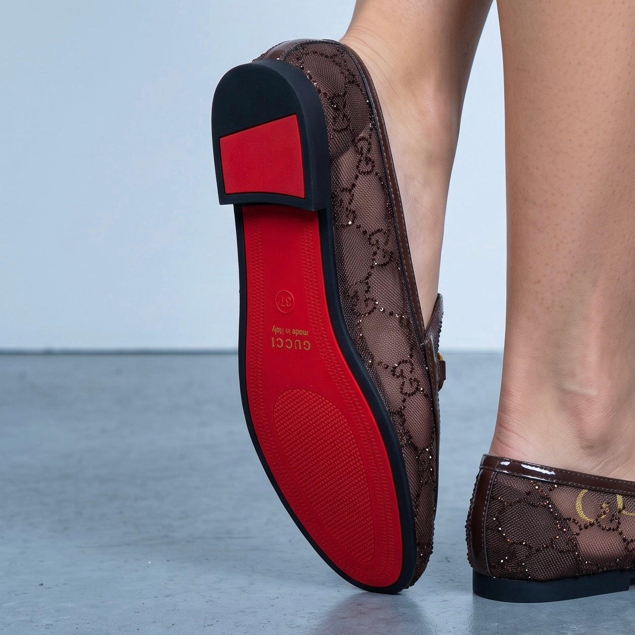 Brown Gucci mesh loafers with gold horsebit and red sole
