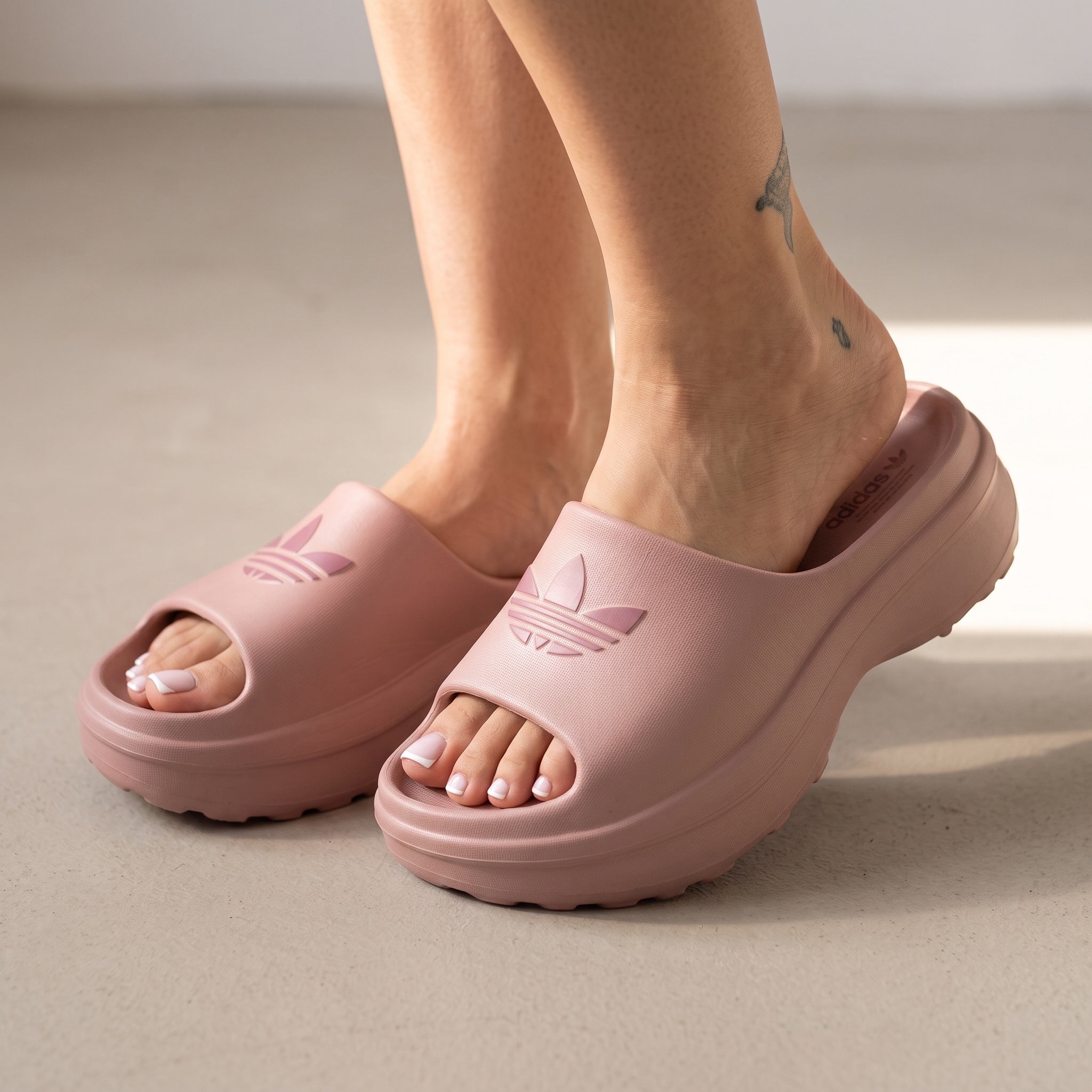 blush pink Adidas platform slide with embossed trefoil logo