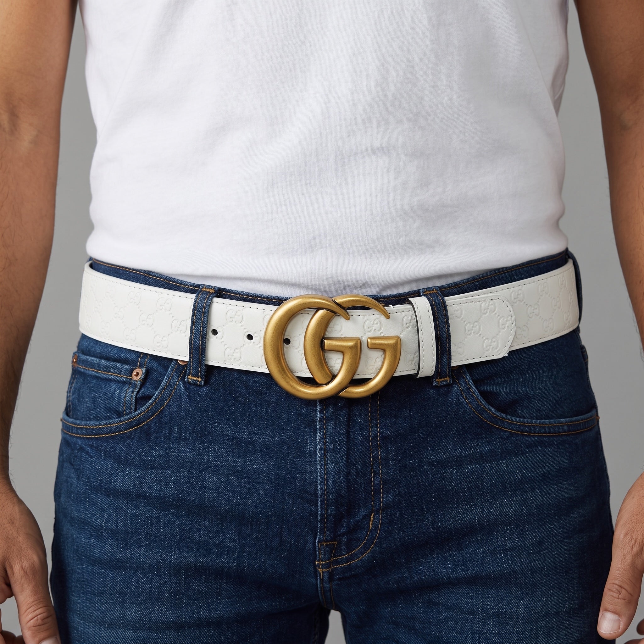 White Gucci belt with gold double G buckle and embossed GG pattern