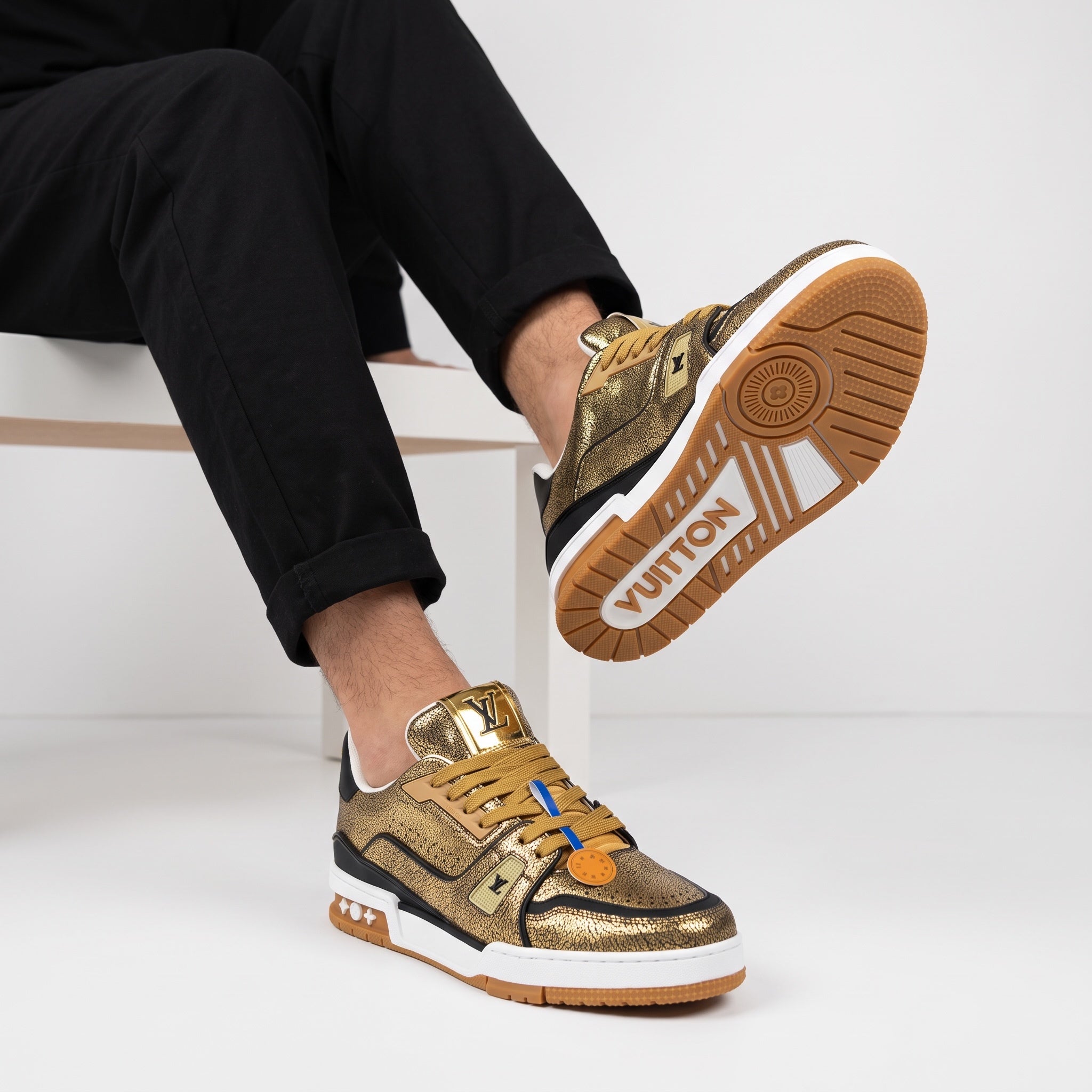 Louis Vuitton gold crackle low-top trainer with gum sole showing VUITTON on outsole