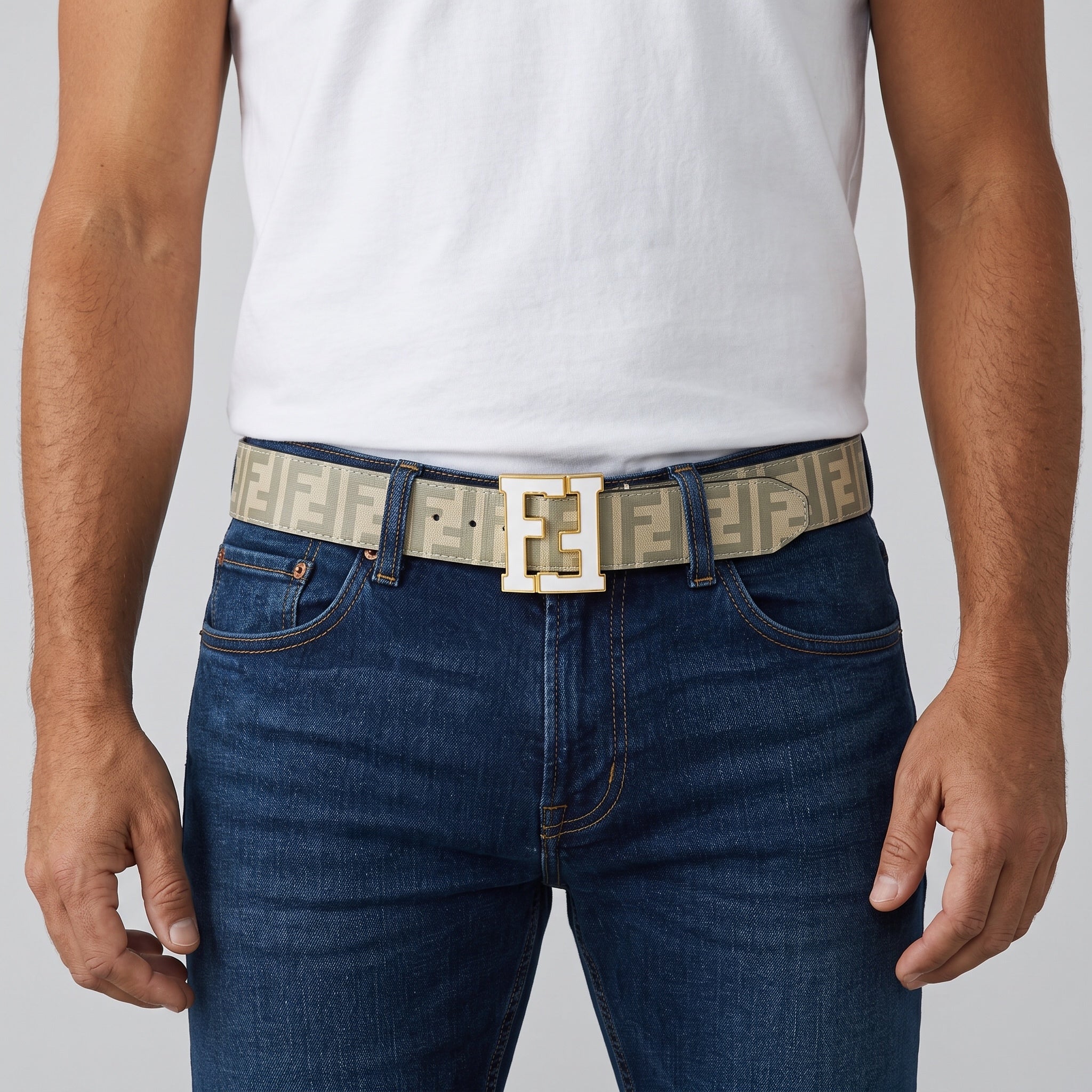 Beige Fendi monogram belt with gold F buckle worn with jeans.