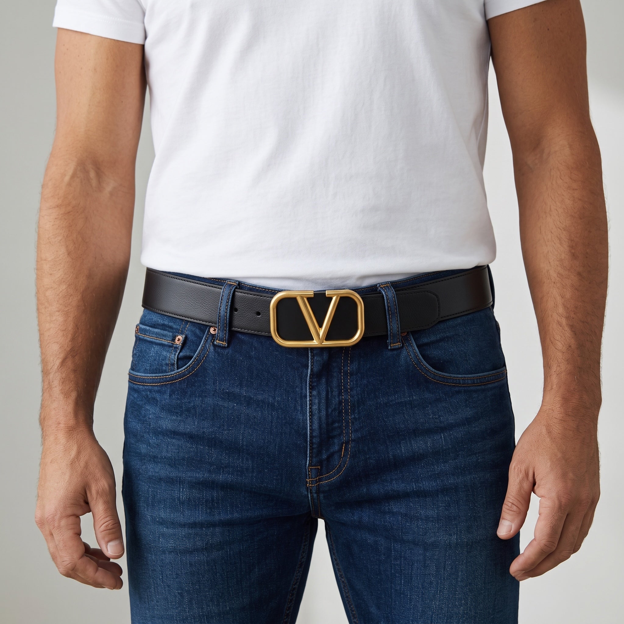 Black belt with gold Valentino V logo buckle worn with jeans