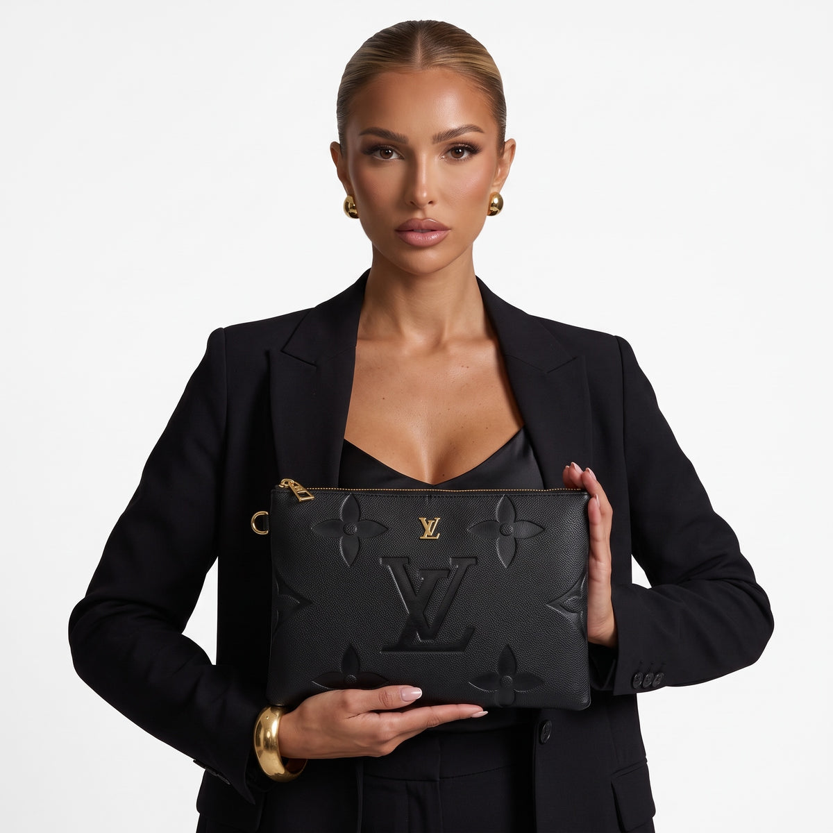 black Louis Vuitton embossed monogram clutch with gold zipper held by model