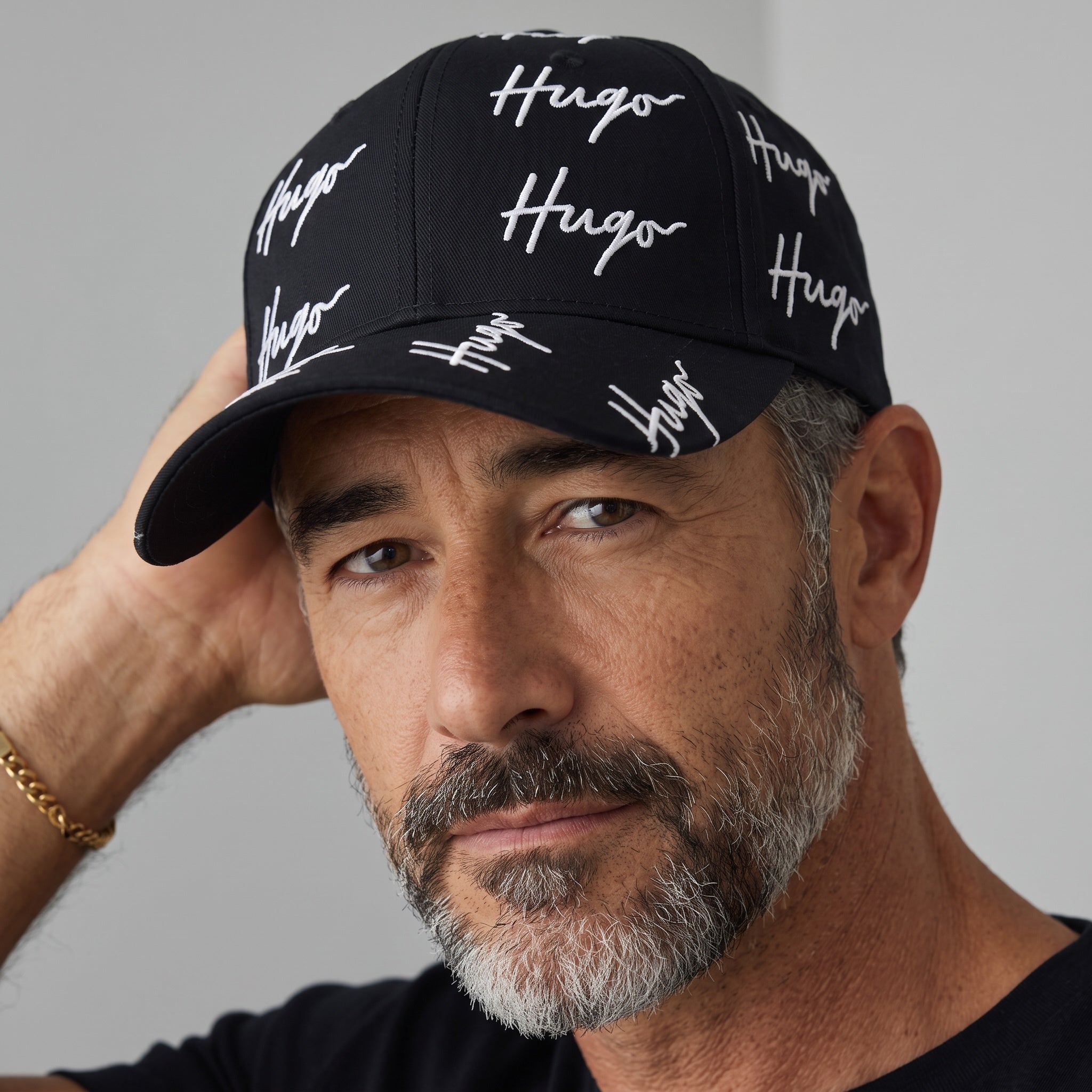 Black HUGO baseball cap with repeated white signature logo print