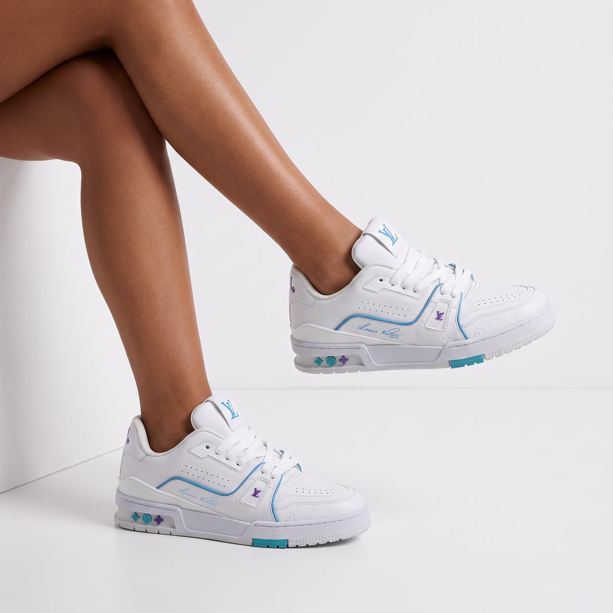 White Louis Vuitton low-top trainer with turquoise and purple accents, LV logo on tongue and embossed monogram