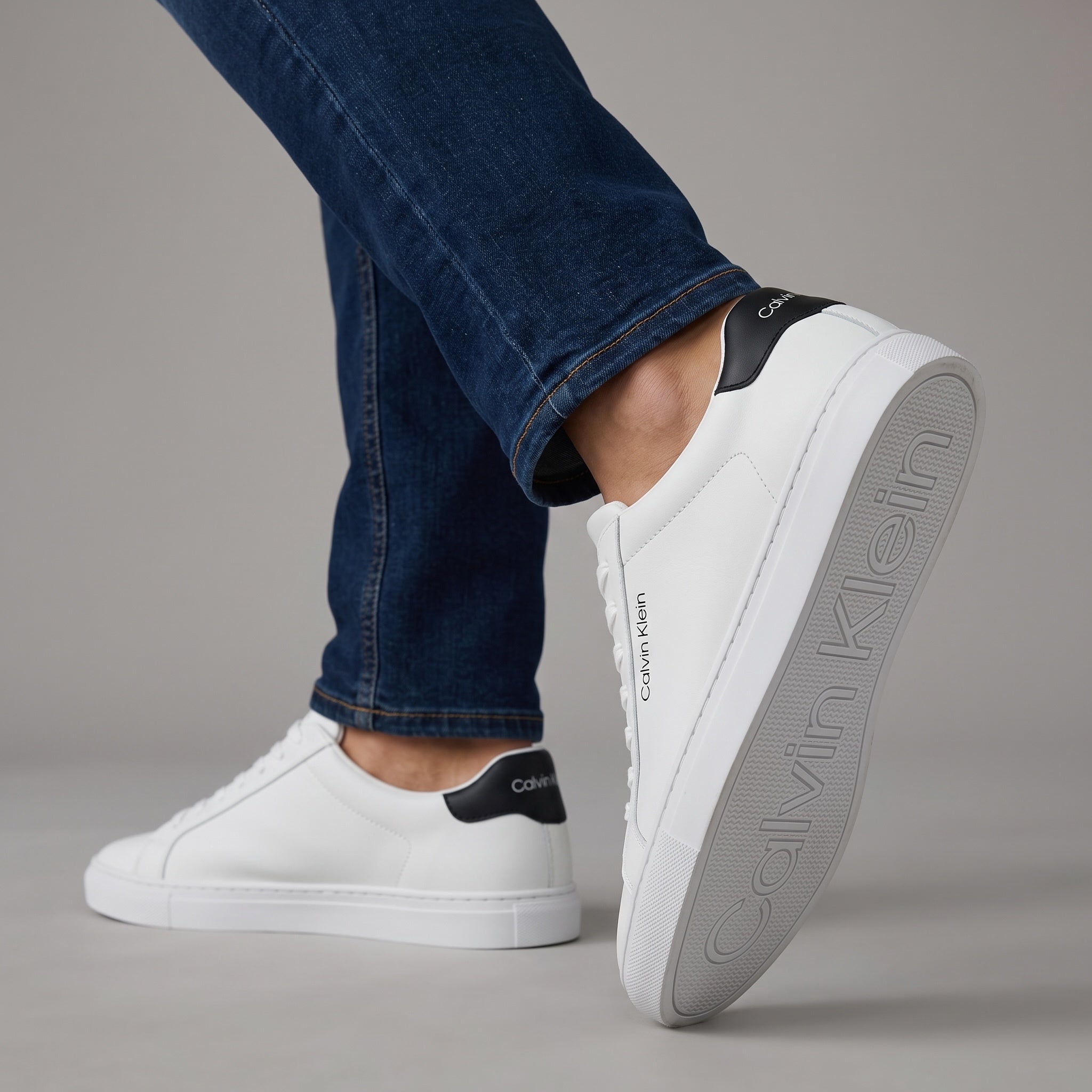 White low-top Calvin Klein sneakers with black heel tab and branded sole