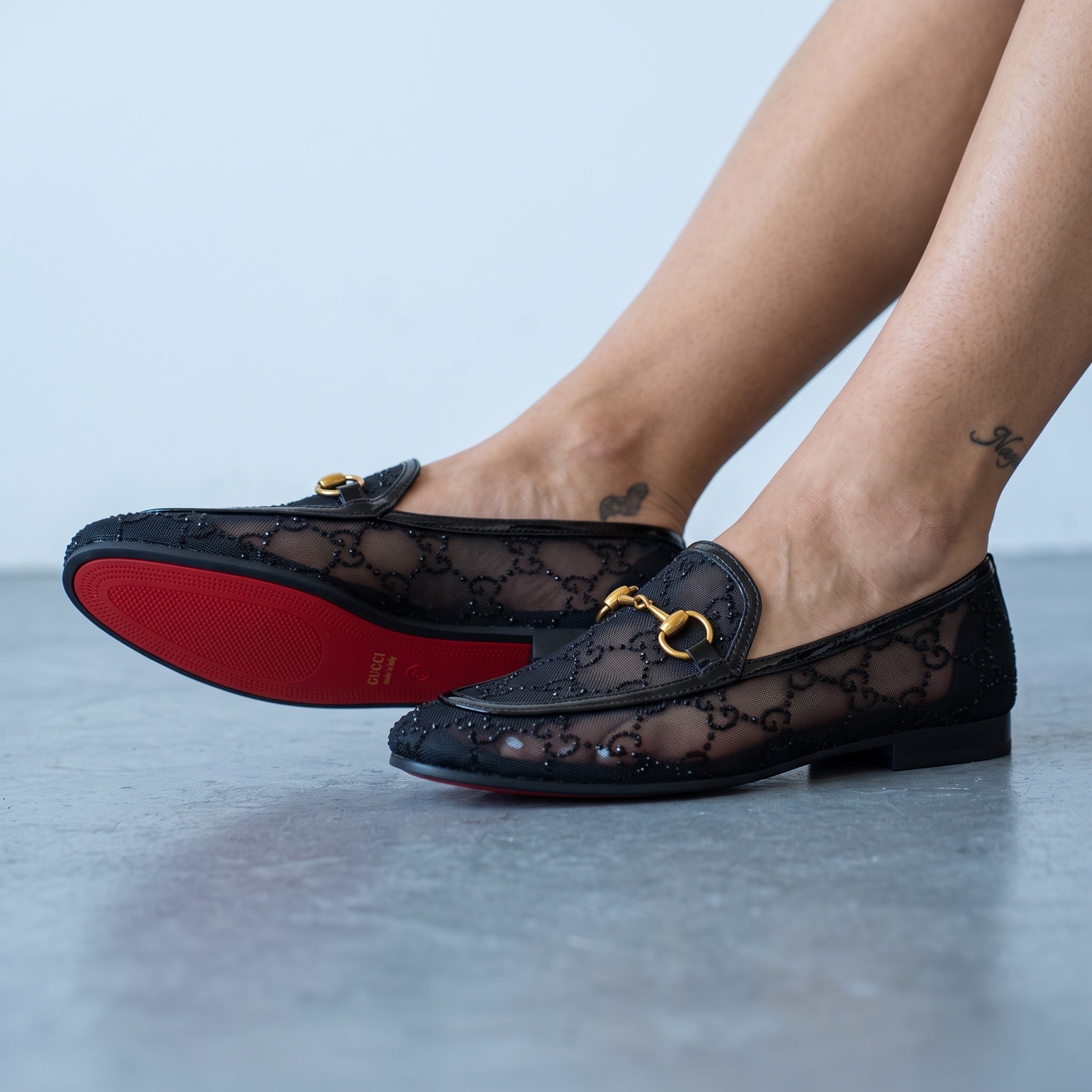 Black Gucci mesh loafers with gold horsebit and red sole