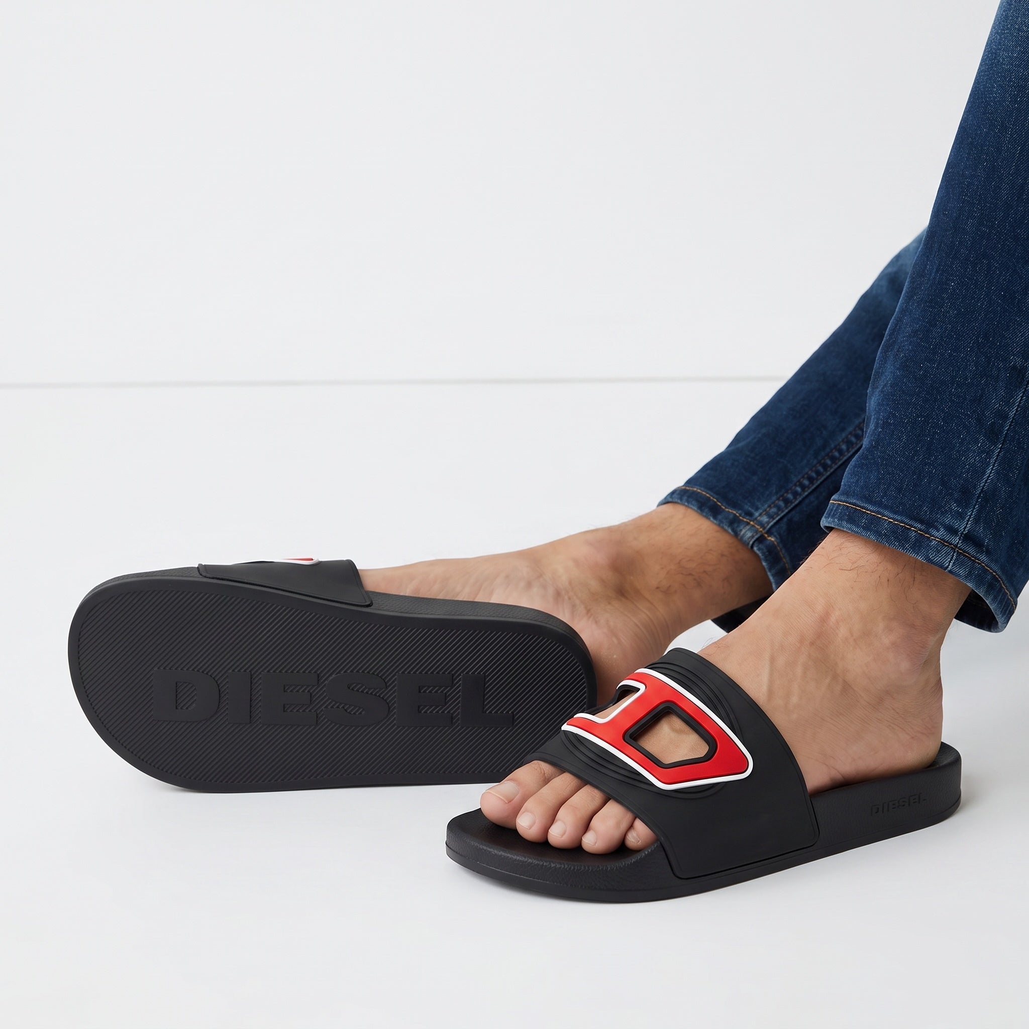 Diesel black slide sandals with red logo on strap and embossed sole