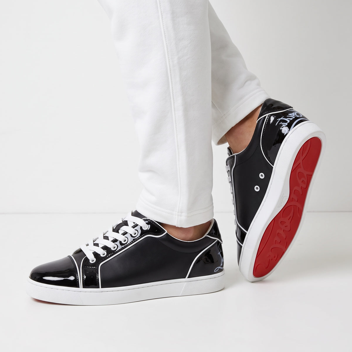 Christian Louboutin black low-top sneakers with red soles and white piping