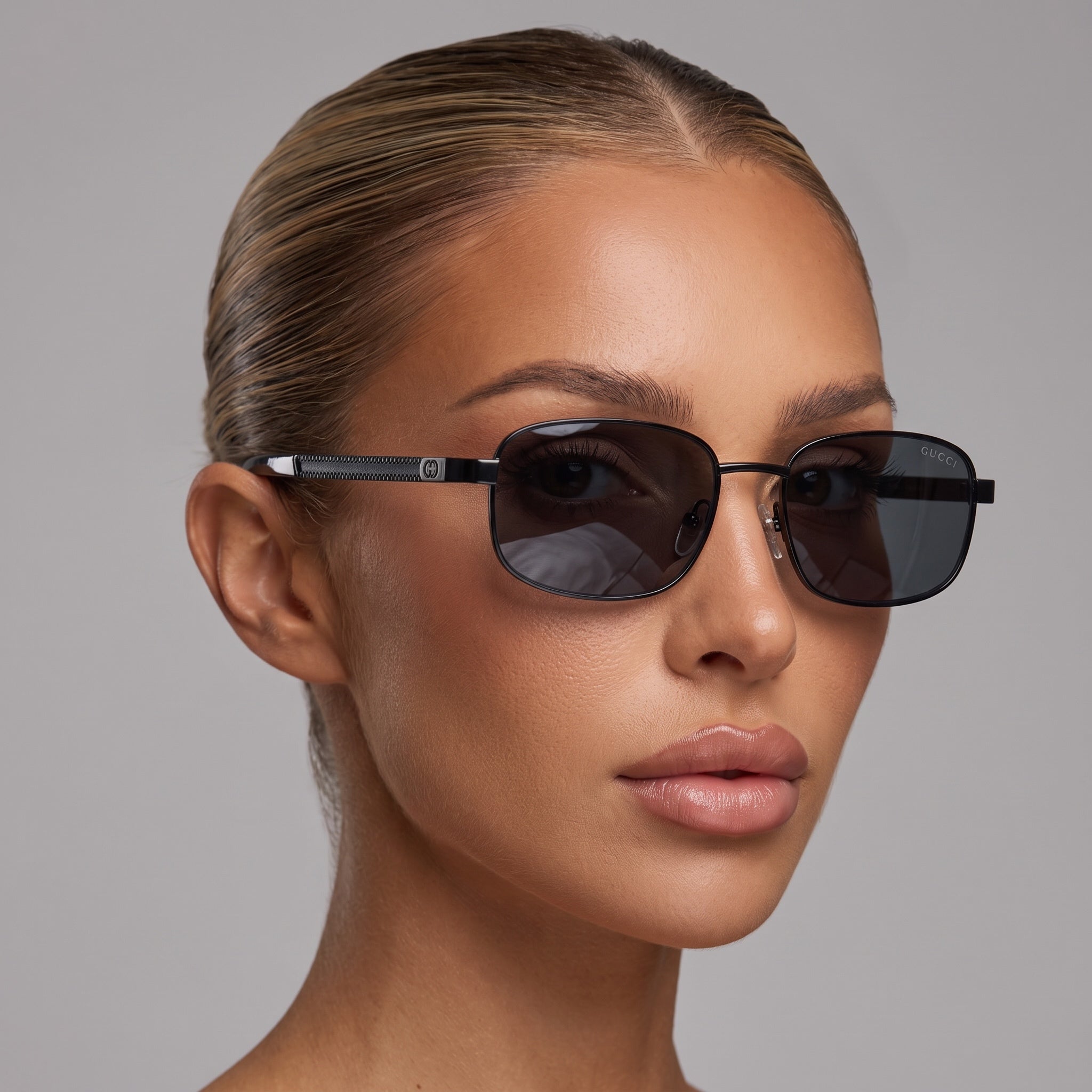 Close-up of model wearing Gucci black metal aviator sunglasses with dark lenses