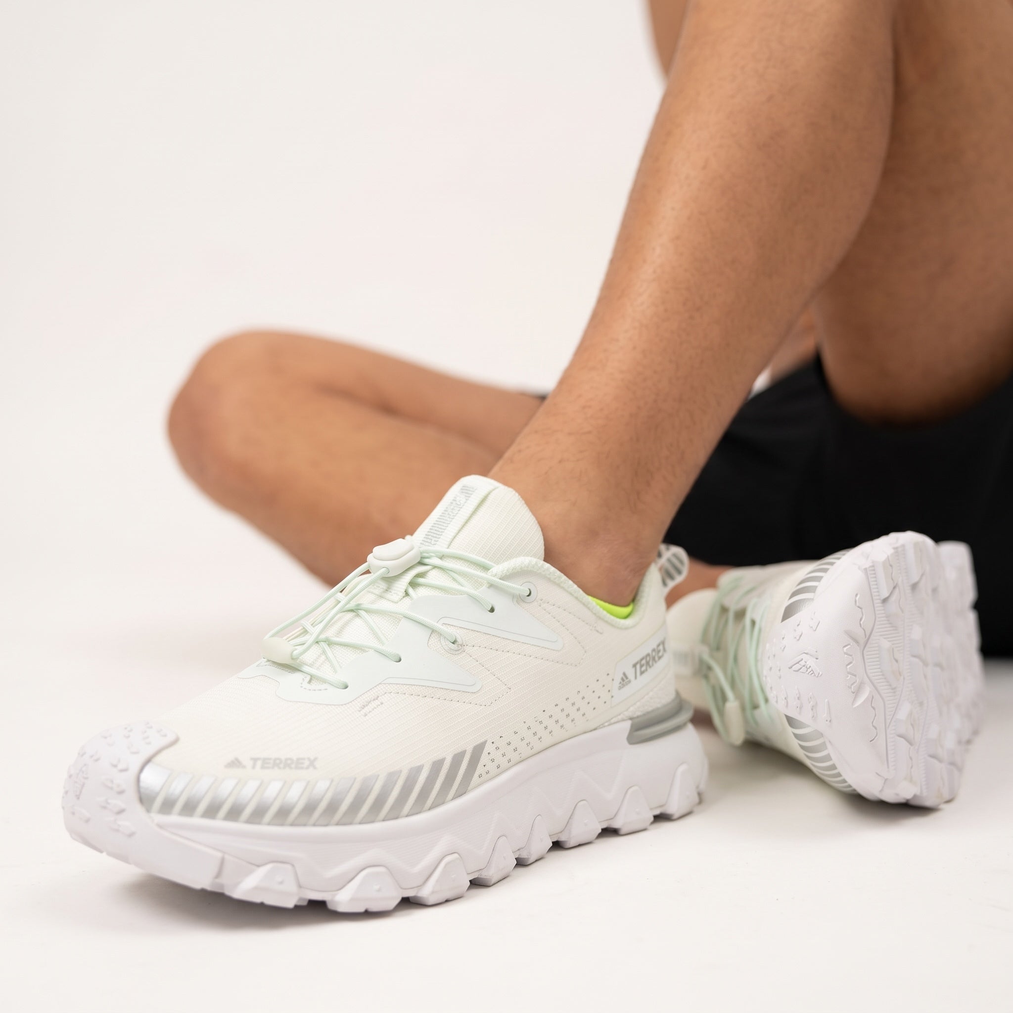 White Adidas Terrex trail sneaker with chunky lug sole and toggle laces