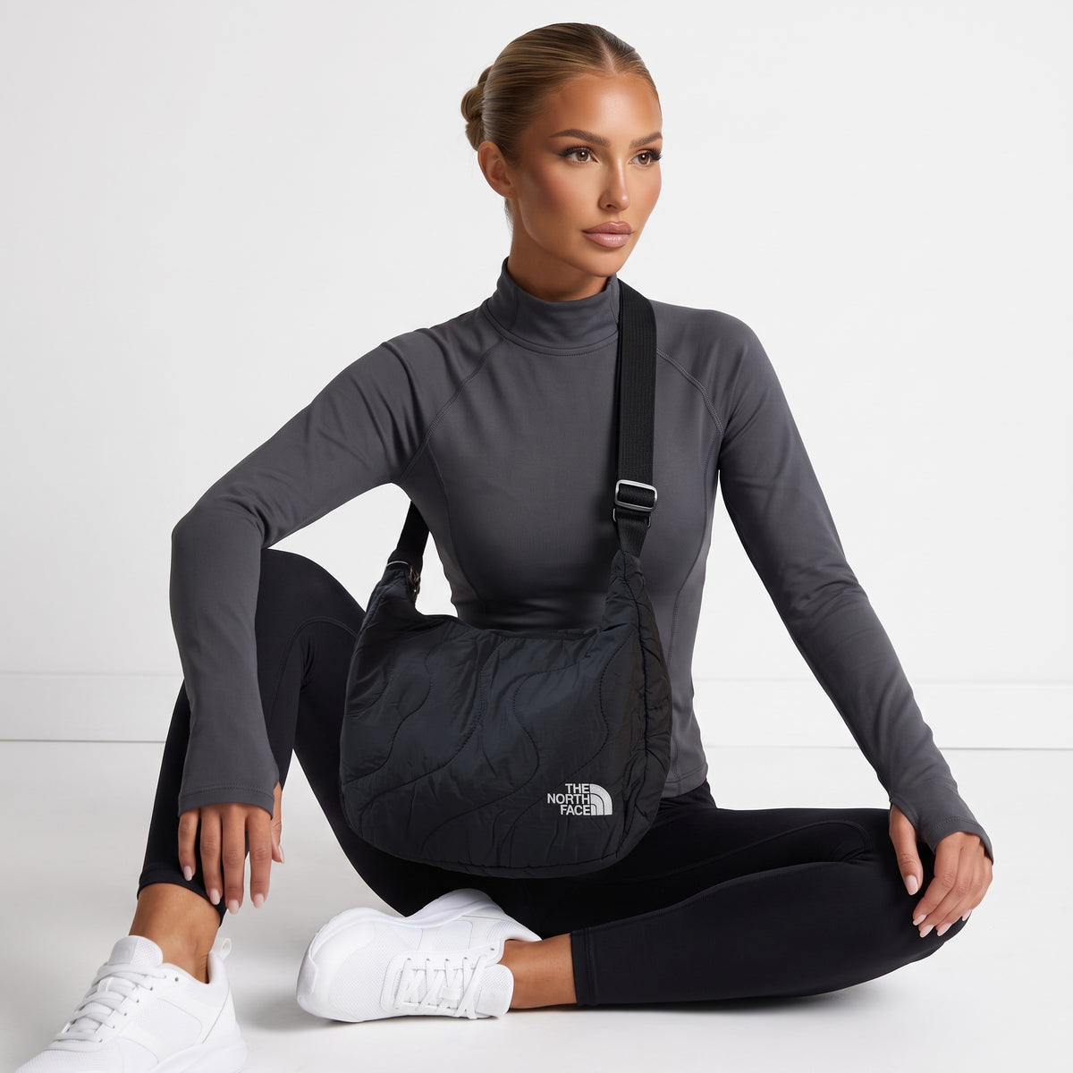 black The North Face quilted shoulder bag with white logo and adjustable strap