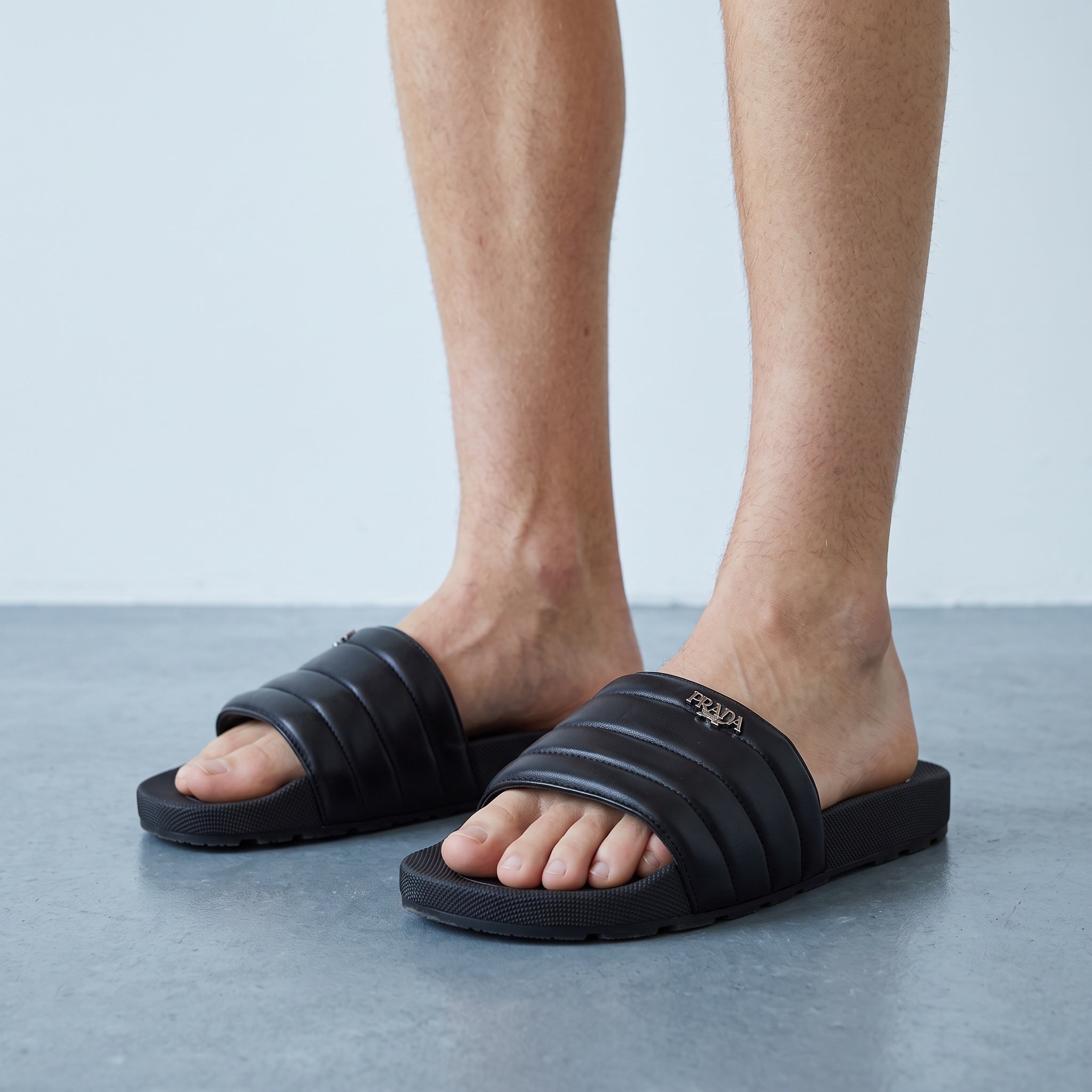 Black Prada padded platform slide sandals with metal logo on strap