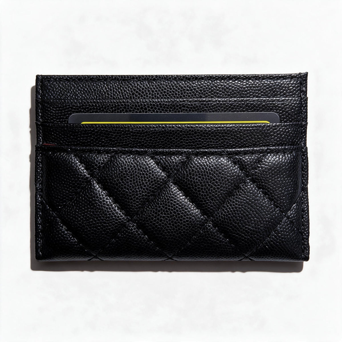 Black quilted Chanel card holder with silver CC logo and card slots
