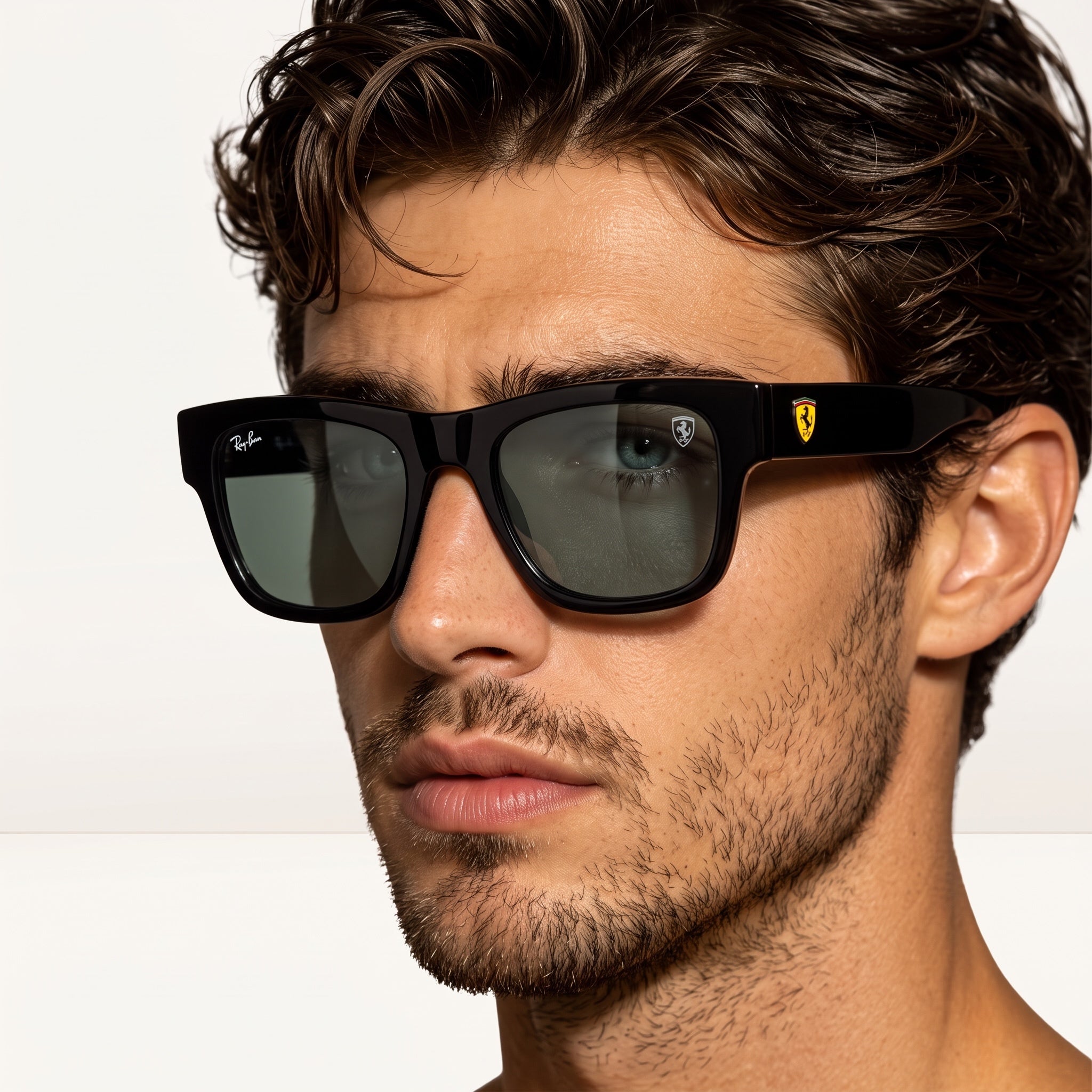 Ray‑Ban x Ferrari black square sunglasses with green lenses and Ferrari shield on temple