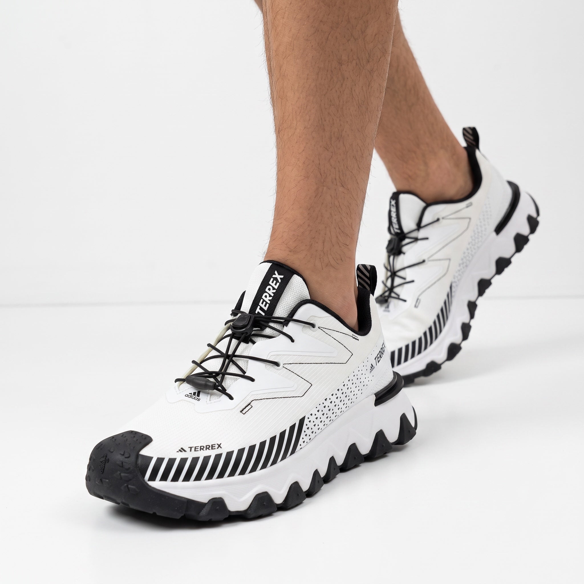 White Adidas Terrex trail running sneaker with black accents and lugged sole