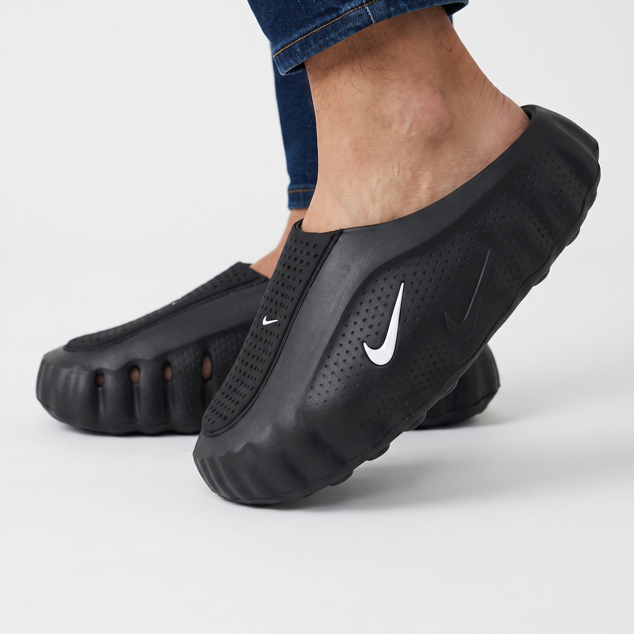 black Nike slip-on clog with perforated upper and white Swoosh