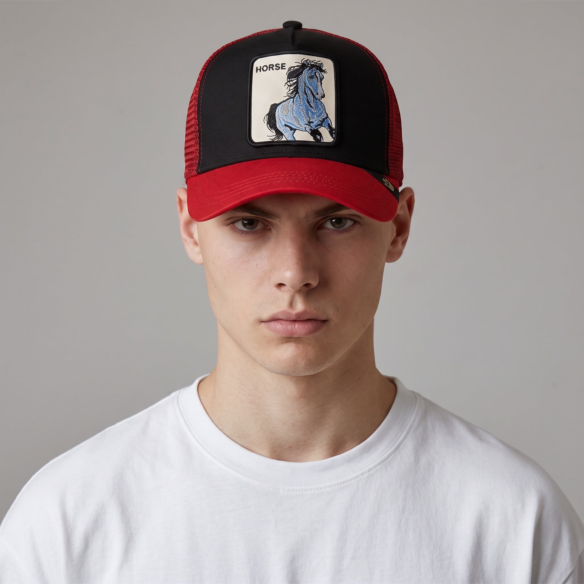 Red and black trucker cap with embroidered horse patch on front