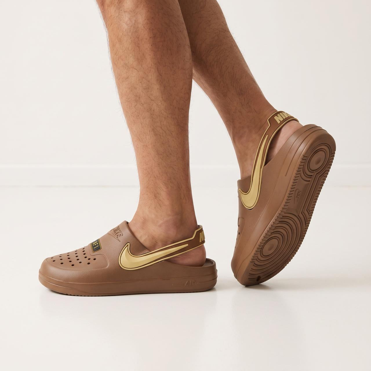 Brown Nike clog with gold swoosh and heel strap shown on model