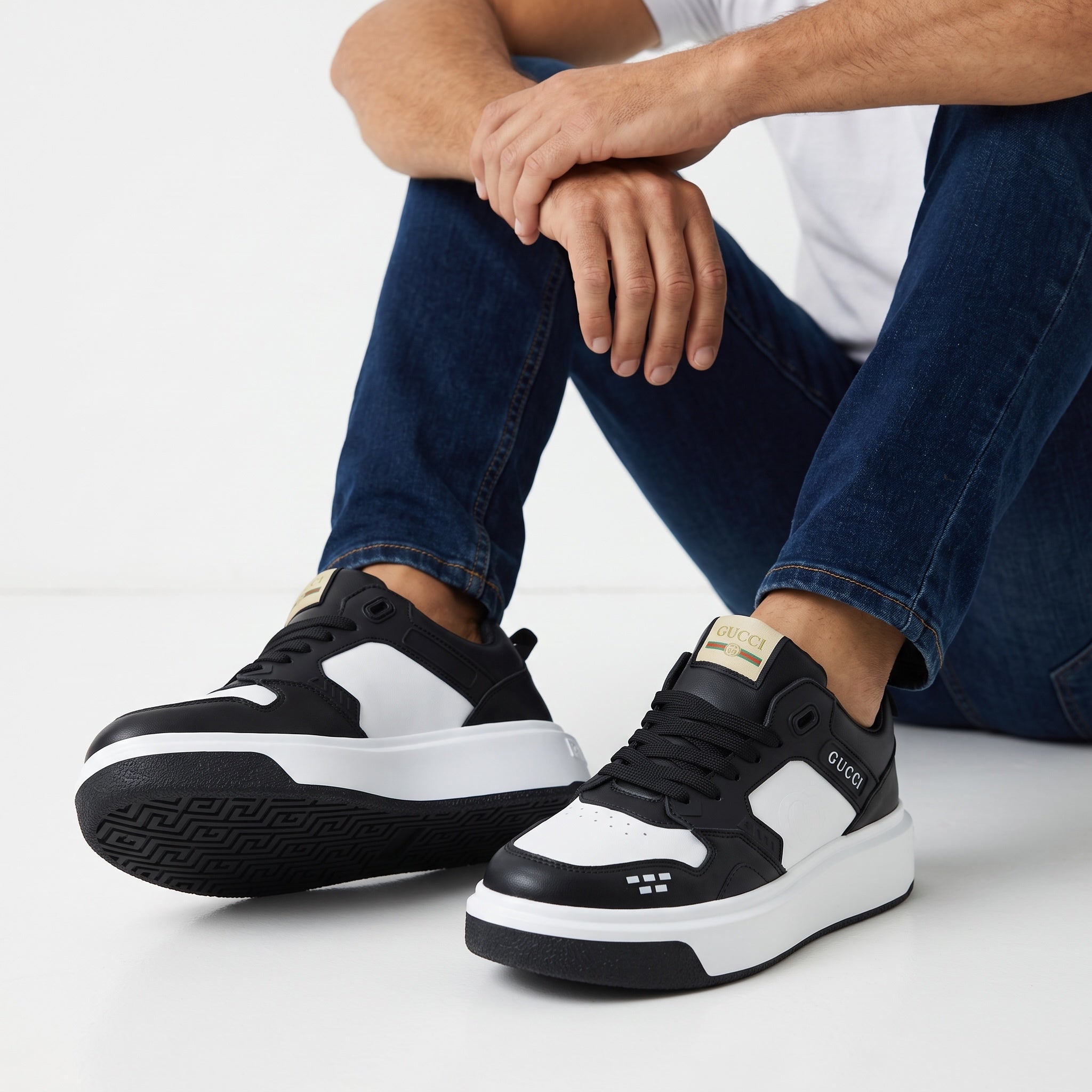 Black and white Gucci chunky sneakers with visible GUCCI logo on side and labeled tongue