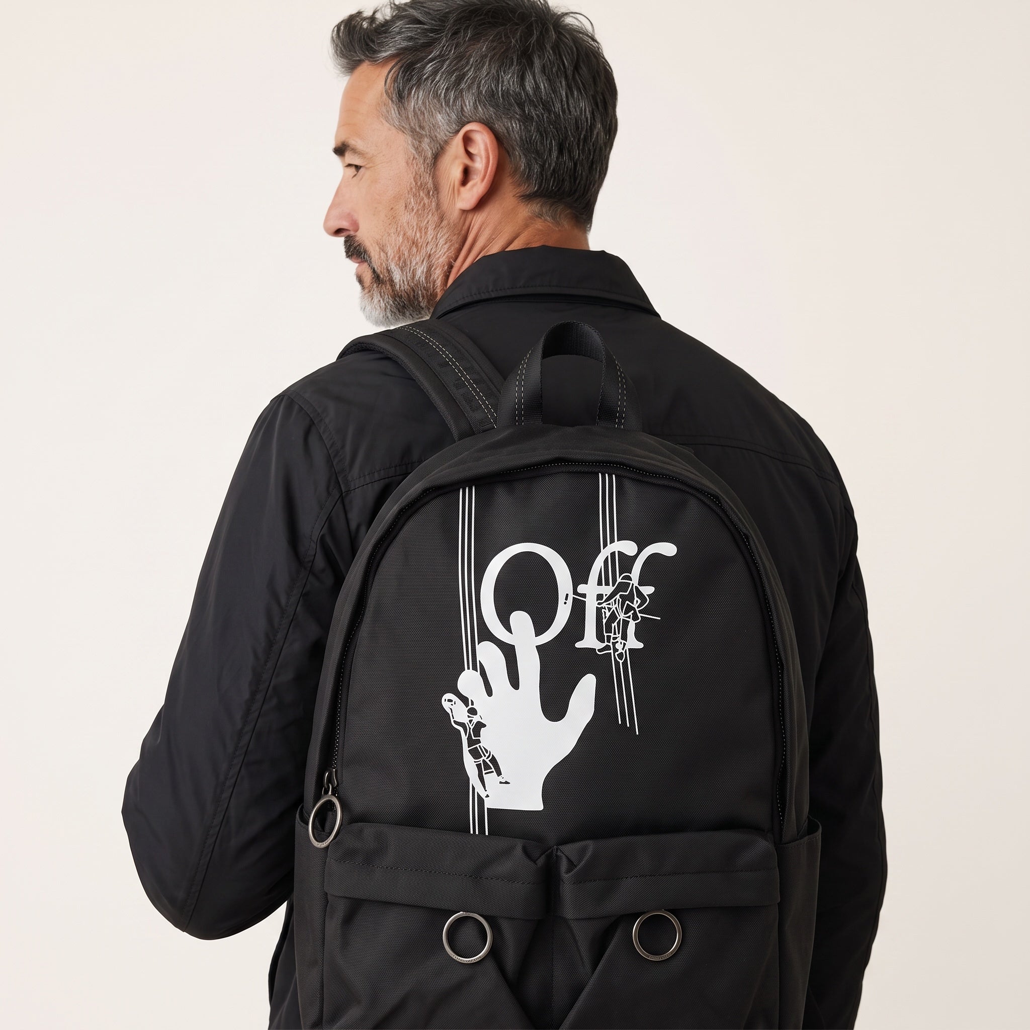 Black Off-White backpack with white logo graphic and metal ring pockets, shown from rear