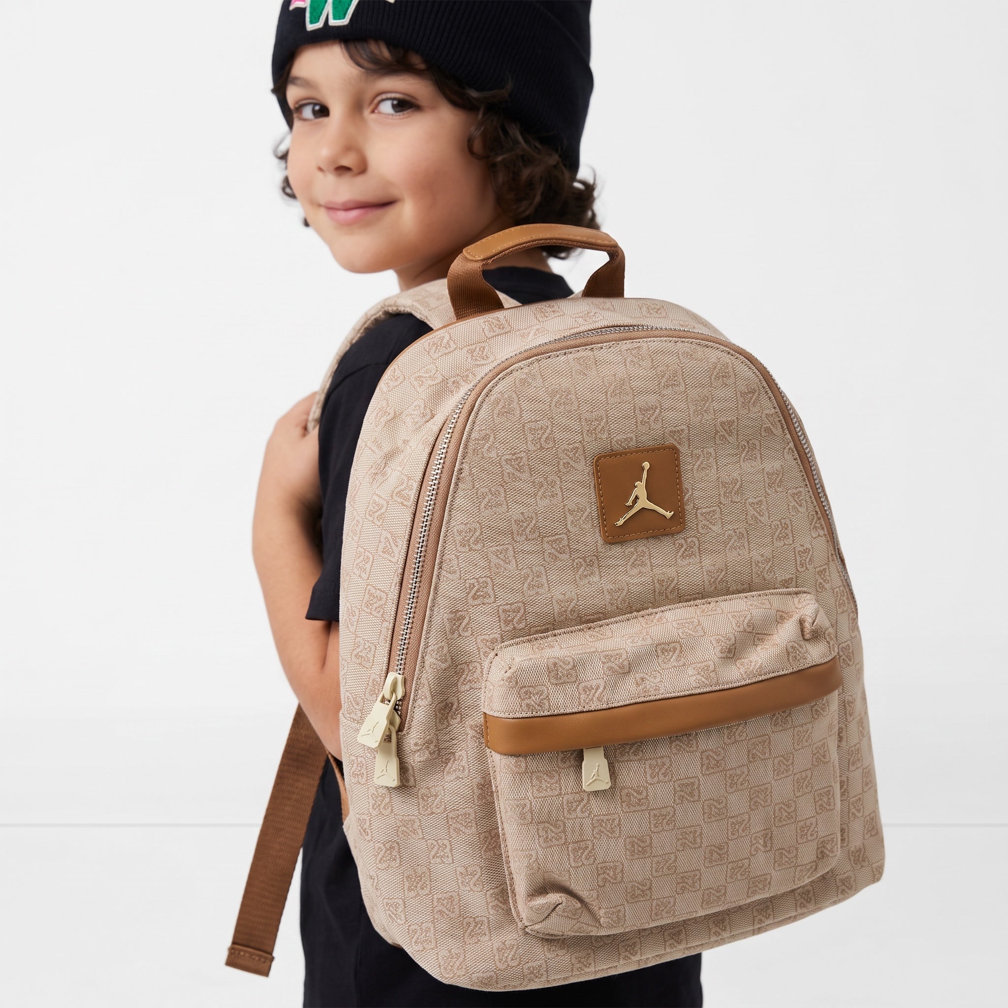 Beige Jordan mini backpack with monogram and gold logo on child model