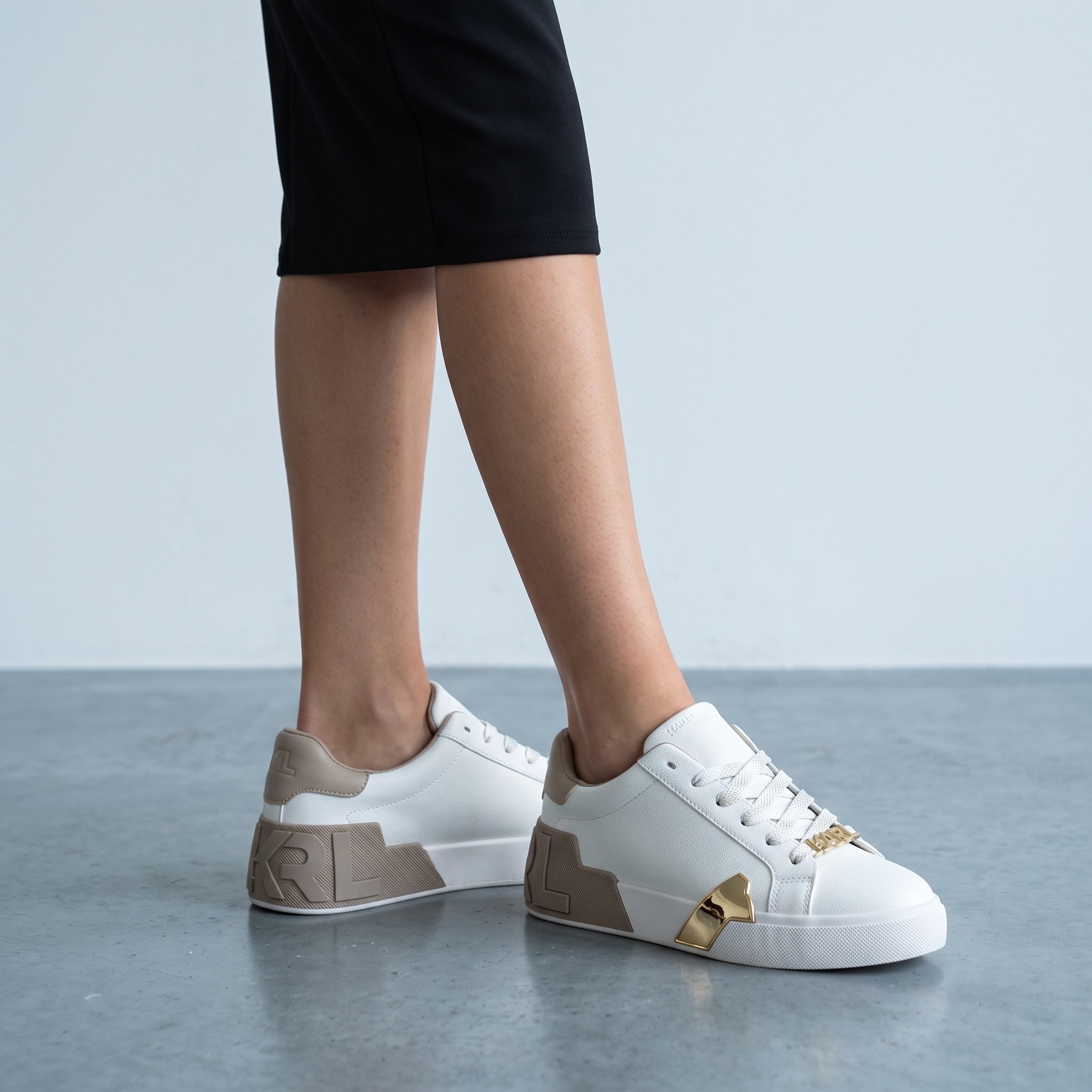 White Karl Lagerfeld low-top sneakers with taupe accents and gold hardware