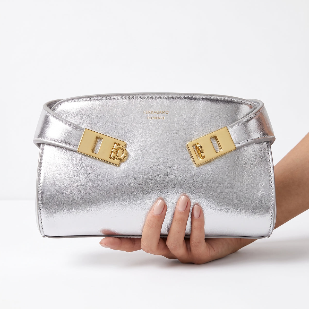 Silver Ferragamo mini bag with gold Gancini hardware and metallic finish