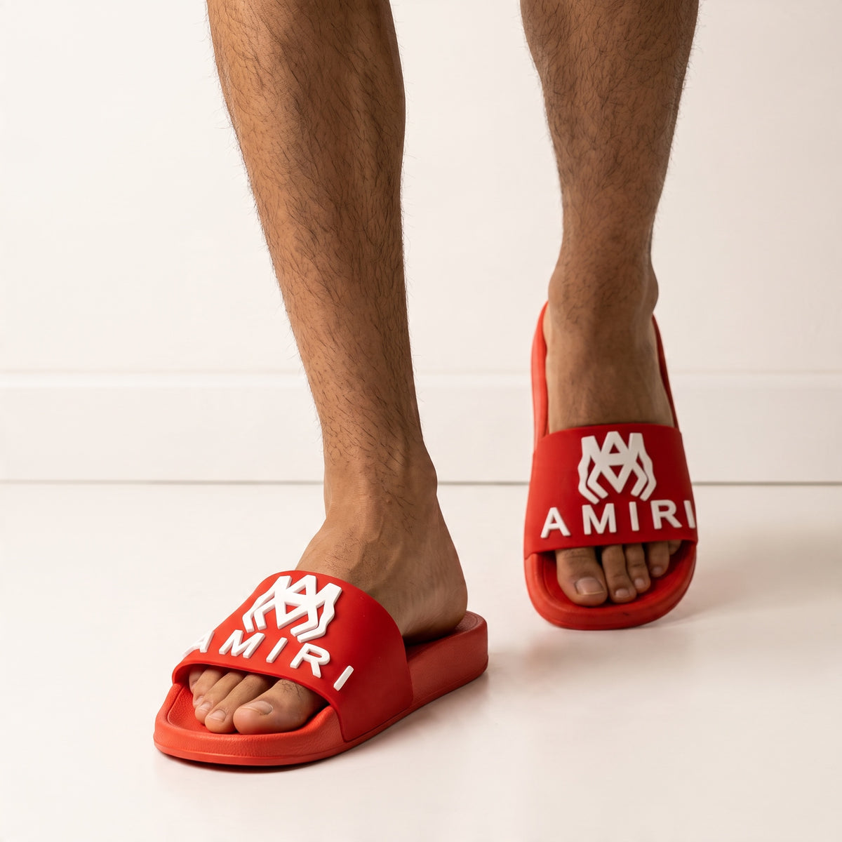Red Amiri logo slide sandal on model feet