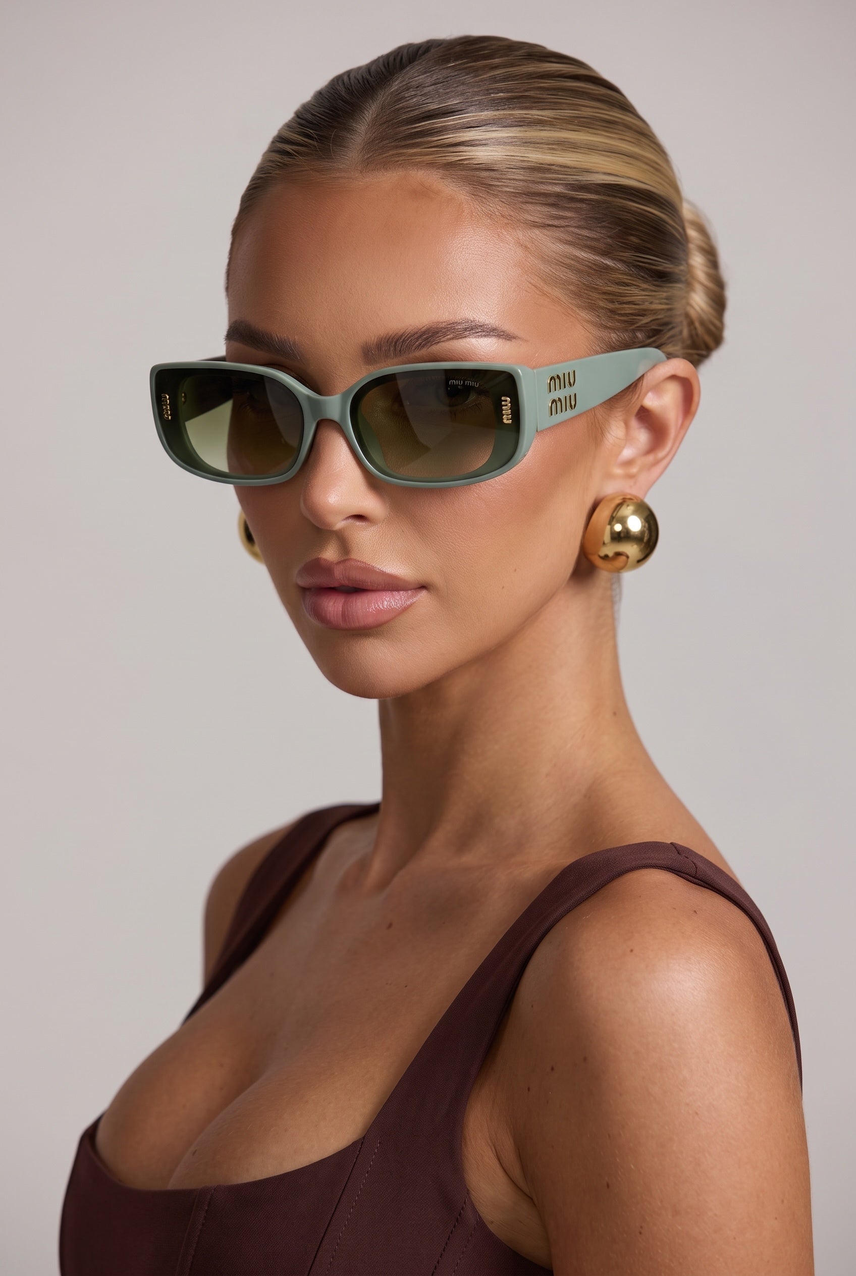Miu Miu mint green rectangular sunglasses with gold logo on temples