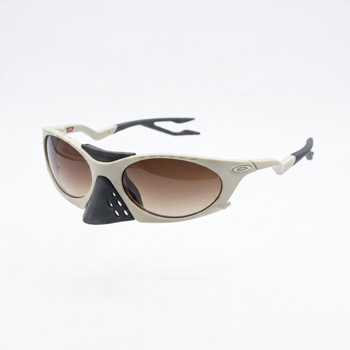 Oakley beige sport sunglasses with brown gradient lenses and ventilated nose guard