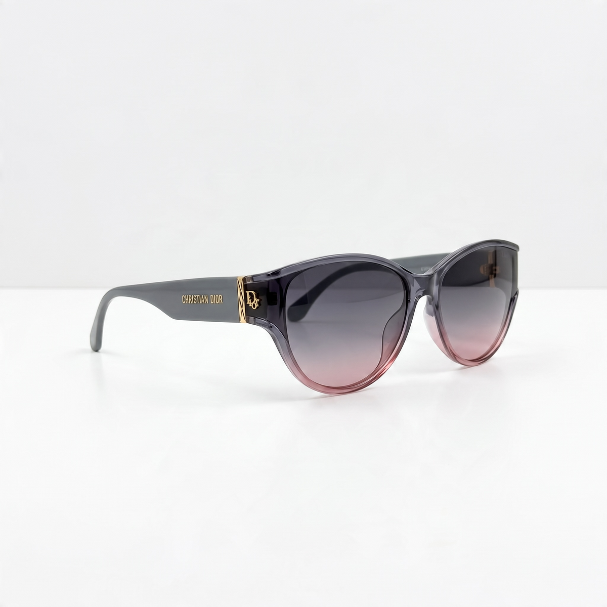 Christian Dior oversized cat-eye sunglasses with grey to pink gradient lenses and gold logo on temple