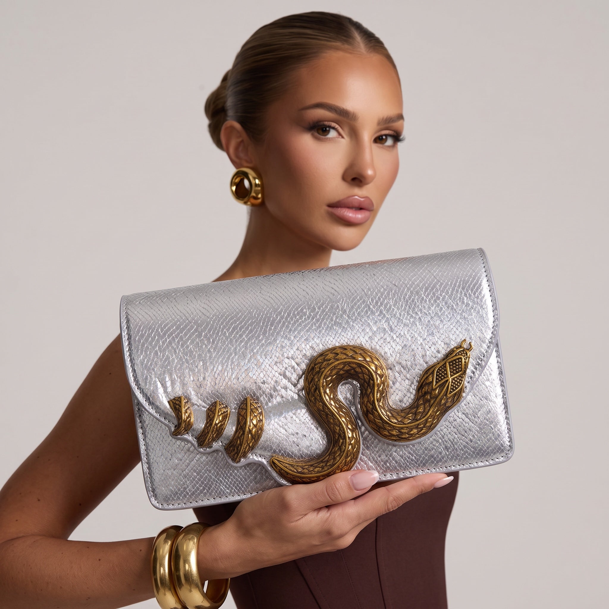 silver textured clutch with gold snake embellishment