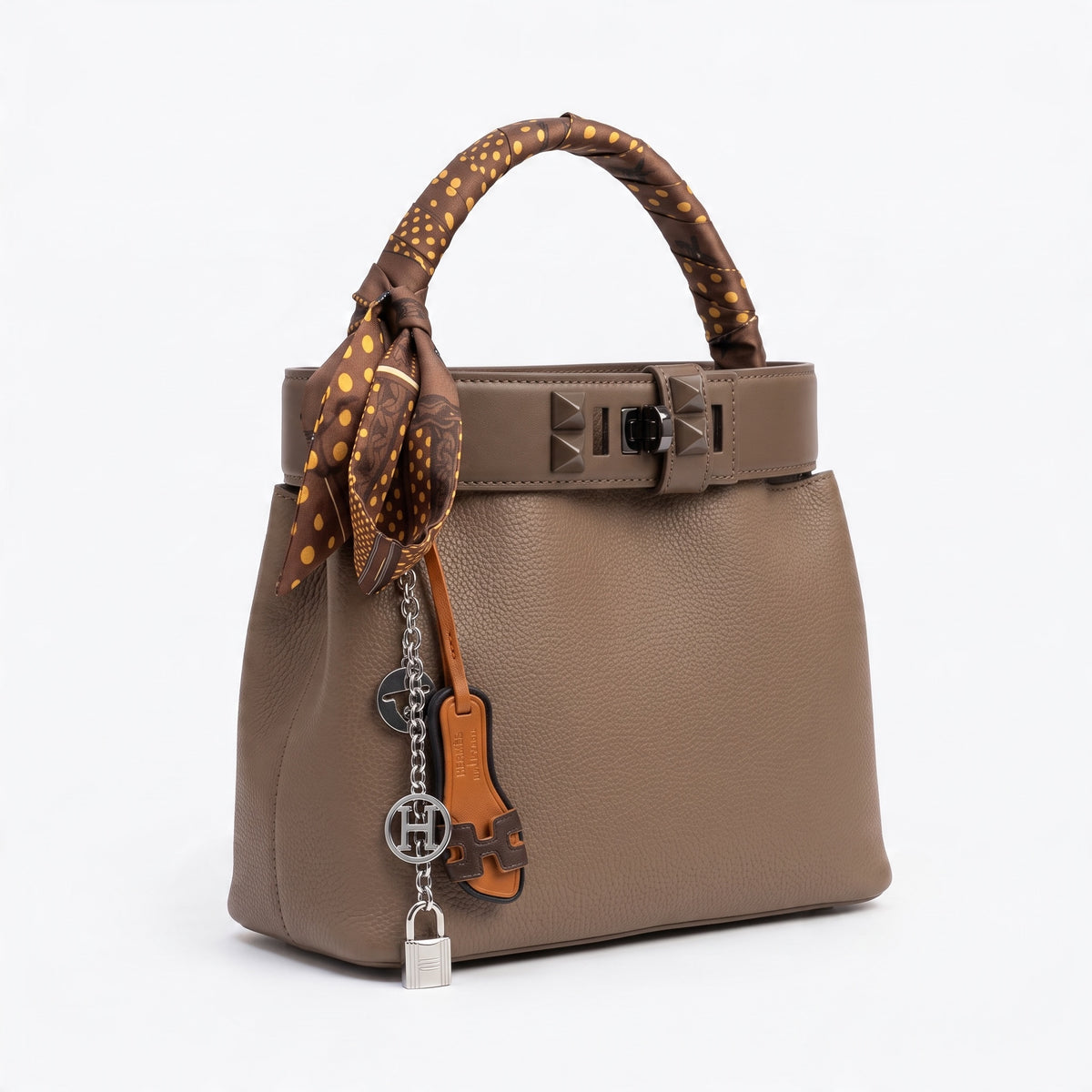 Taupe Hermès bucket bag with twilly-wrapped handle and charm