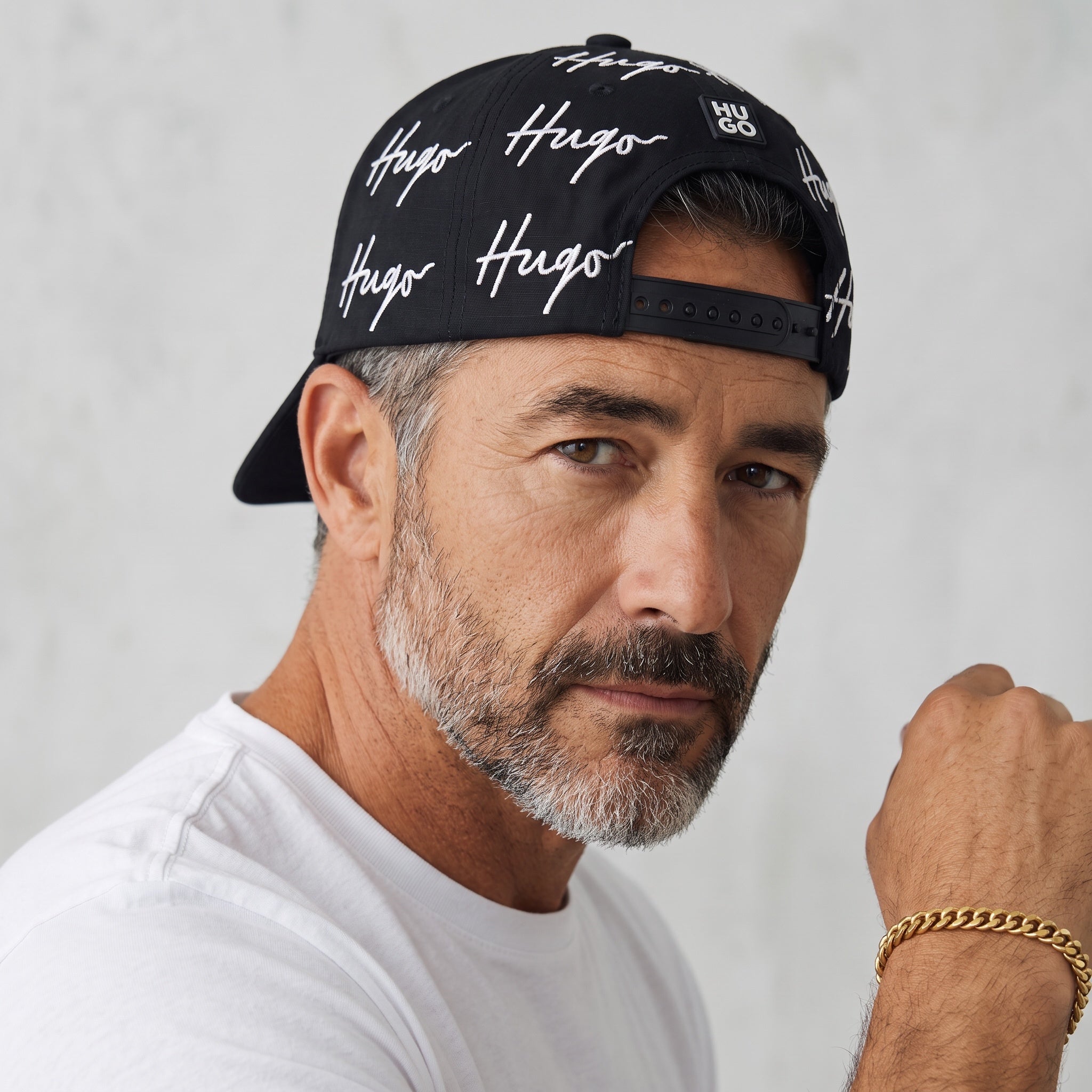 Black HUGO baseball cap with repeated white signature logo print