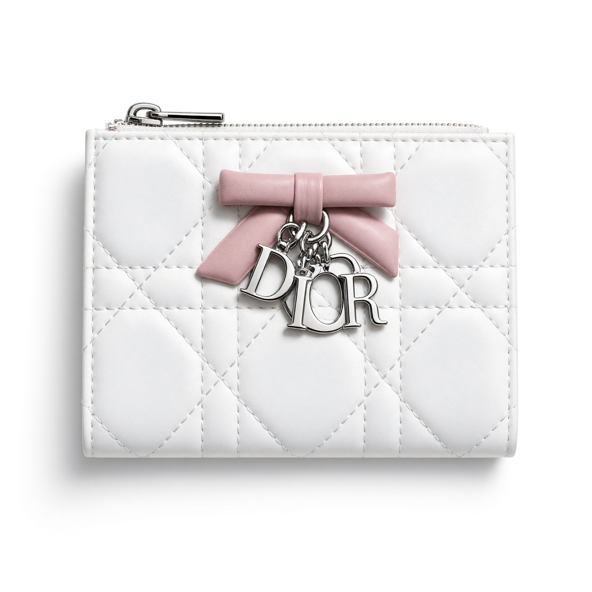 White quilted Dior compact wallet with pink bow and silver Dior charms, opened to show pink interior card slots